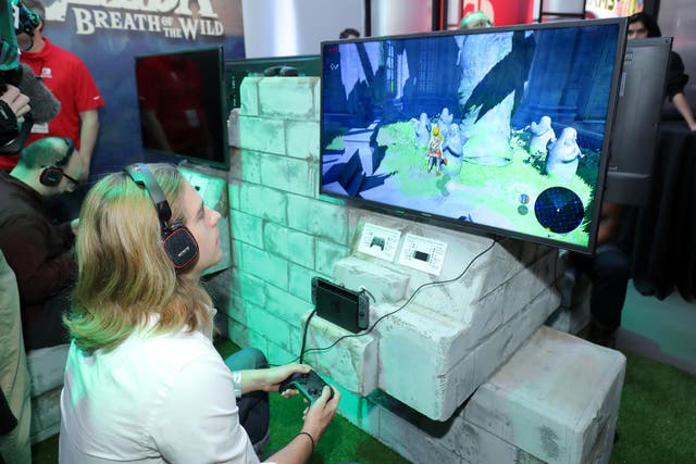 <p>In this photo provided by Nintendo of America, a guest enjoys playing The Legend of Zelda: Breath of the Wild on the groundbreaking new Nintendo Switch at a special preview event in New York</p>
