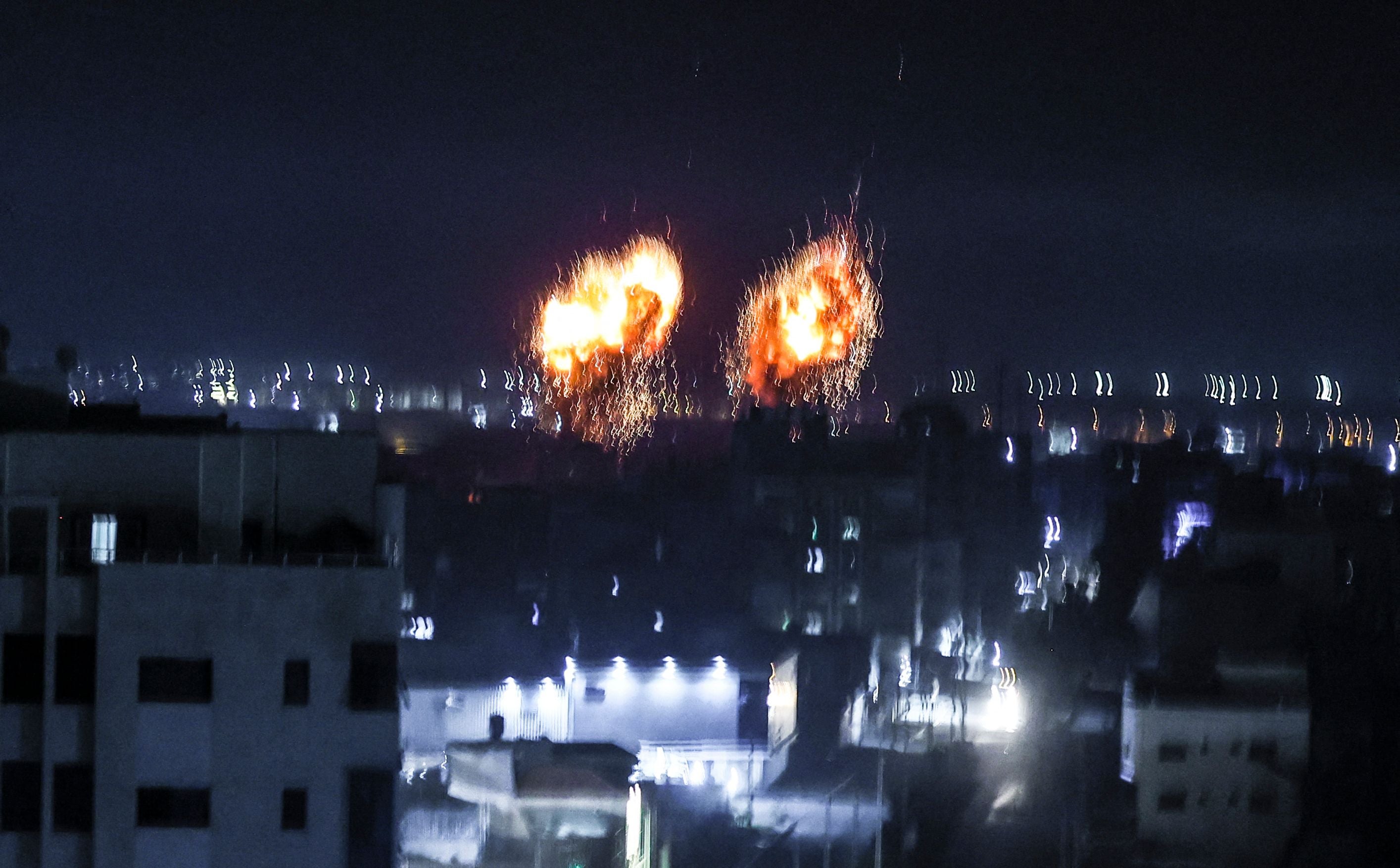 Explosions lit up the night sky about building in Gaza city as Israeli forces shelled the Palestinian enclave, in response to incendiary balloons.