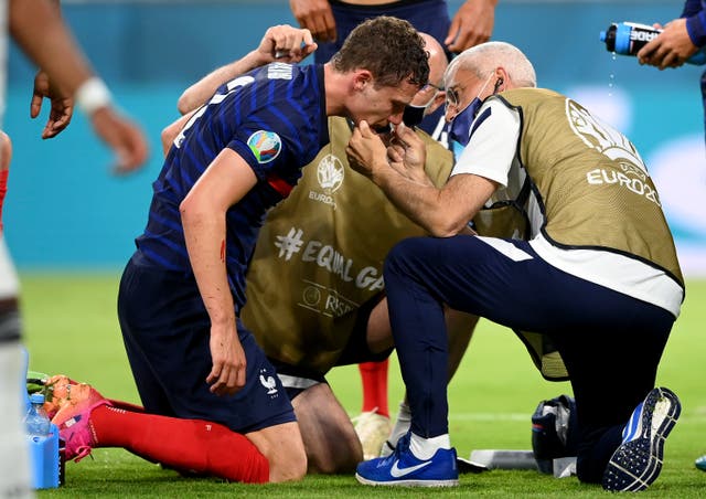 <p>Benjamin Pavard receives treatment after his collision with Germany's Robin Gosens on Tuesday night</p>