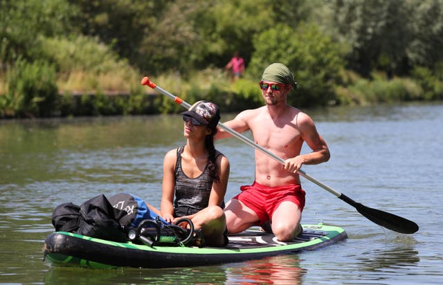 <p>A pair of paddle boarders travel along the River Thames near Donnington Bridge, Oxford</p>