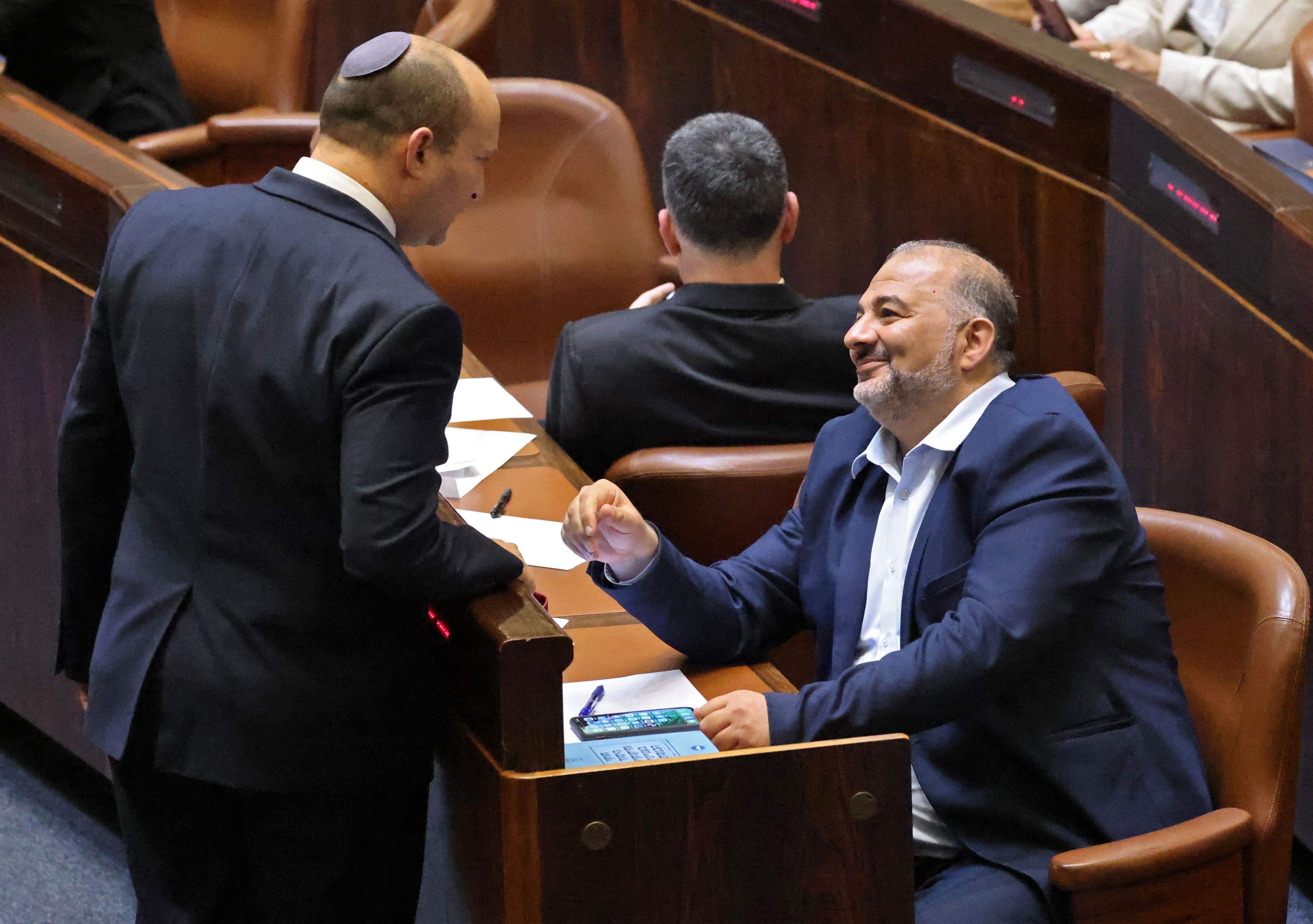 Israel’s new prime minister Naftali Bennett talks with Mansour Abbas, who is part of the new coalition government