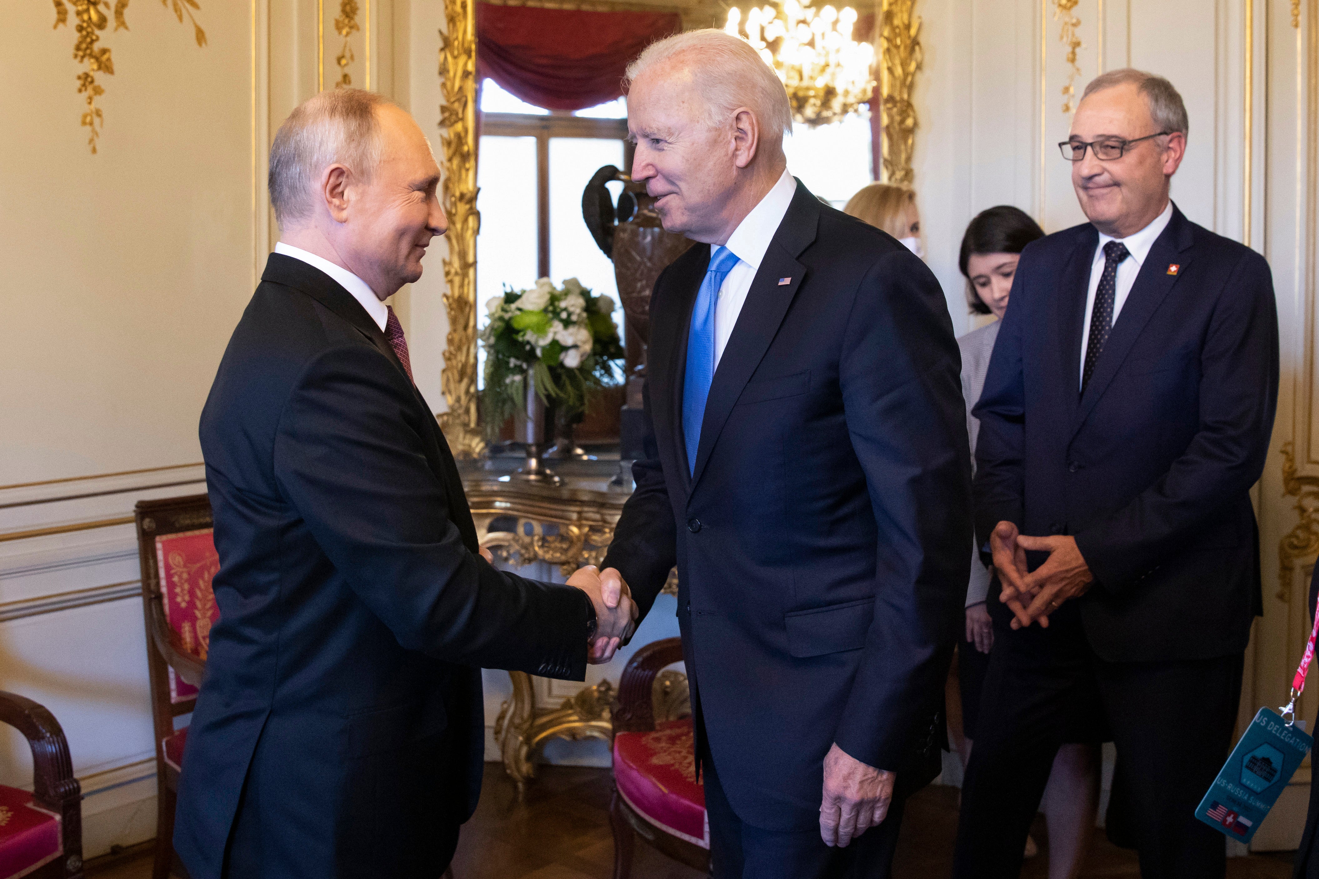 Vladimir Putin shakes hands with Joe Biden during their summit in Geneva