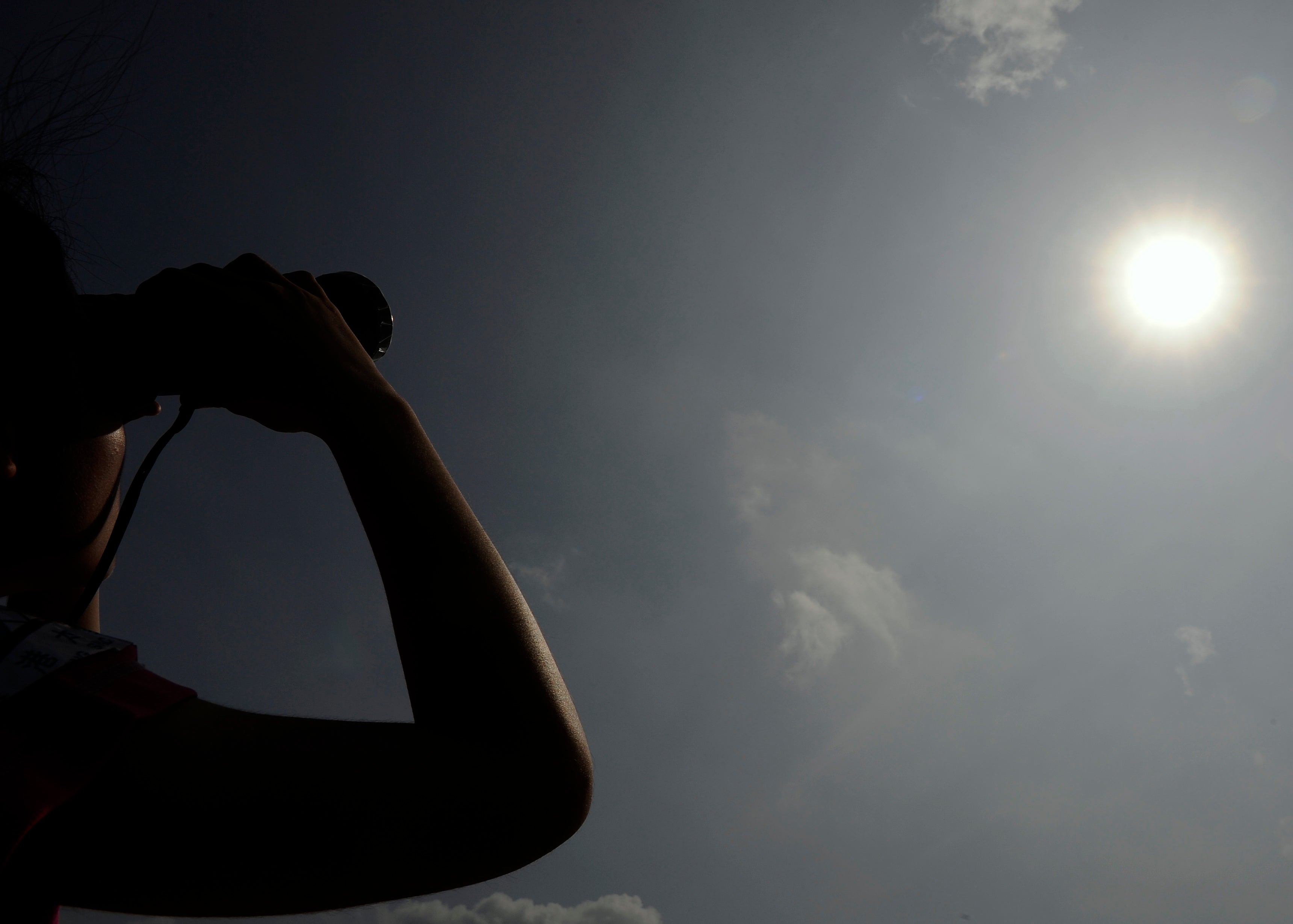 <p>File image: A woman in Hong Kong looks through binoculars as planet Venus orbits between the Sun and the Earth during the transit of Venus on 6 June, 2012.  Earth’s energy imbalance is the difference between the amount of energy it receives and from sun and radiates back </p>