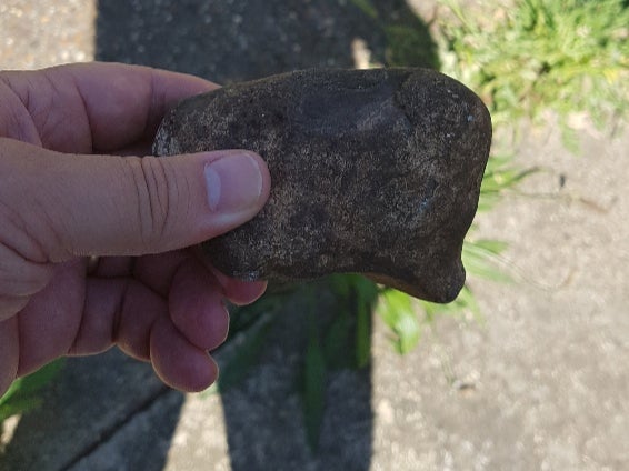 A rock that was catapulted at police officers attending the scene in Stanwell Village, Surrey