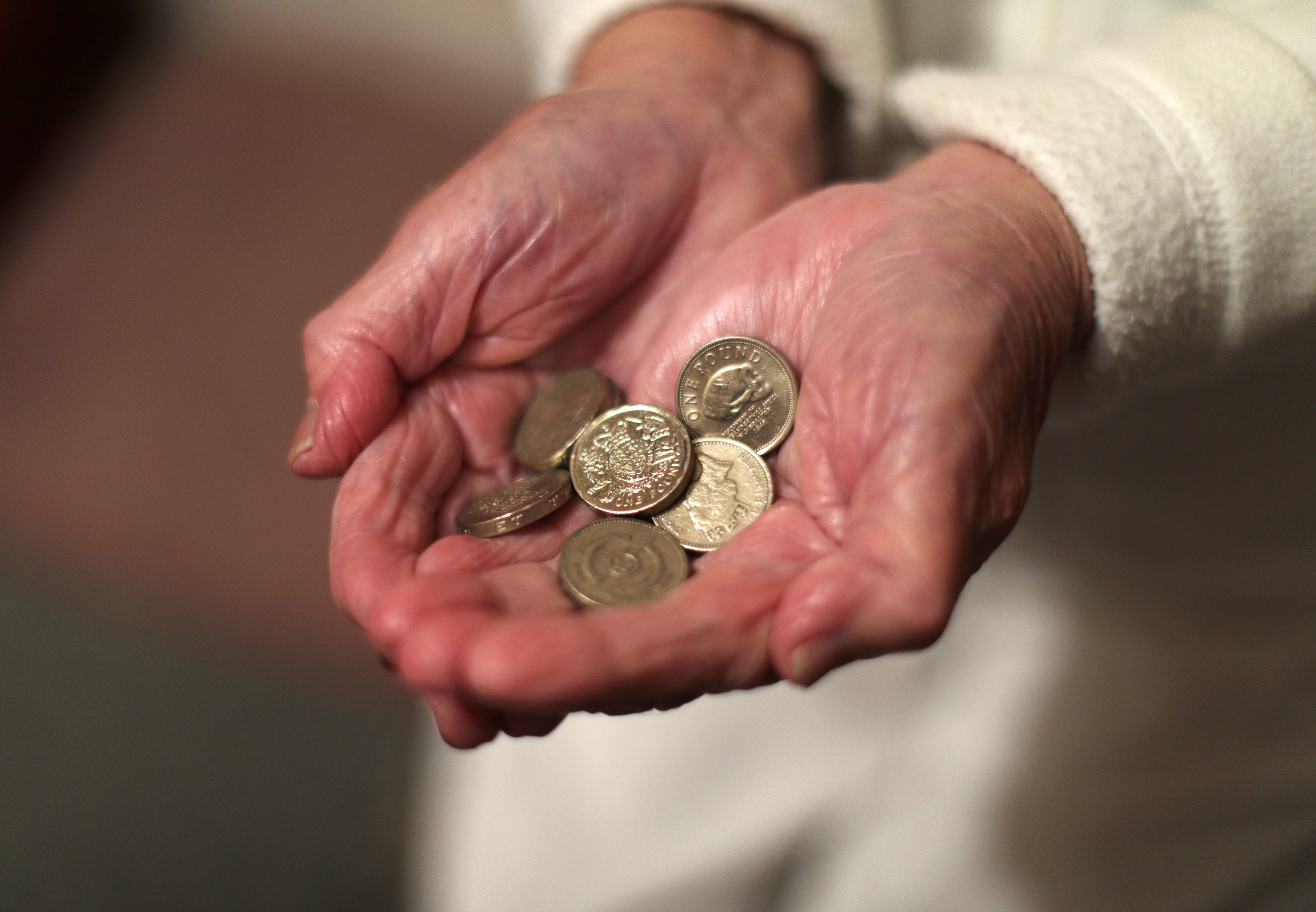 An elderly woman holding coins