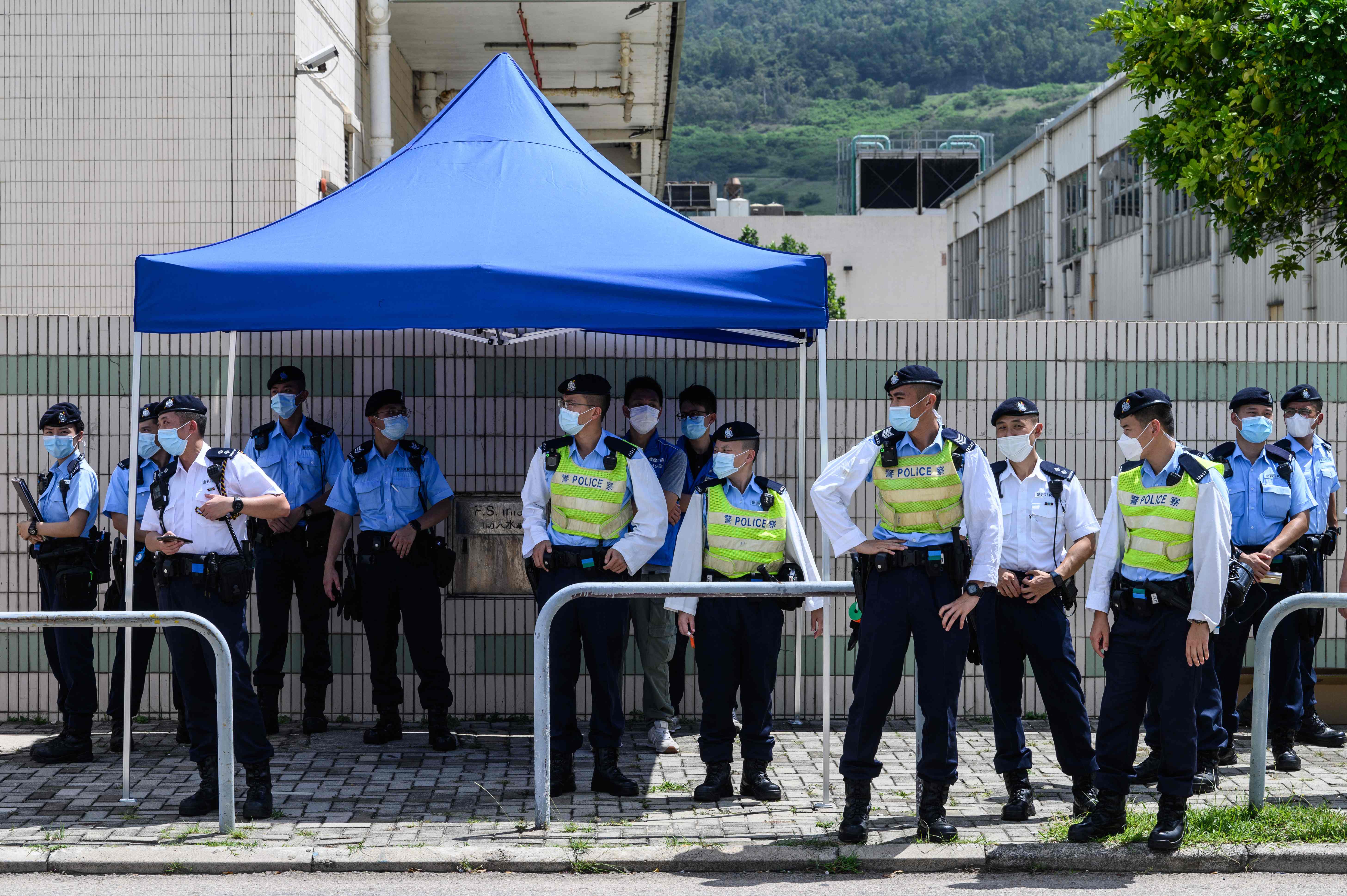 Police stand guard near the offices of the local Apple Daily newspaper in Hong Kong on Thursday after police arrested five executives