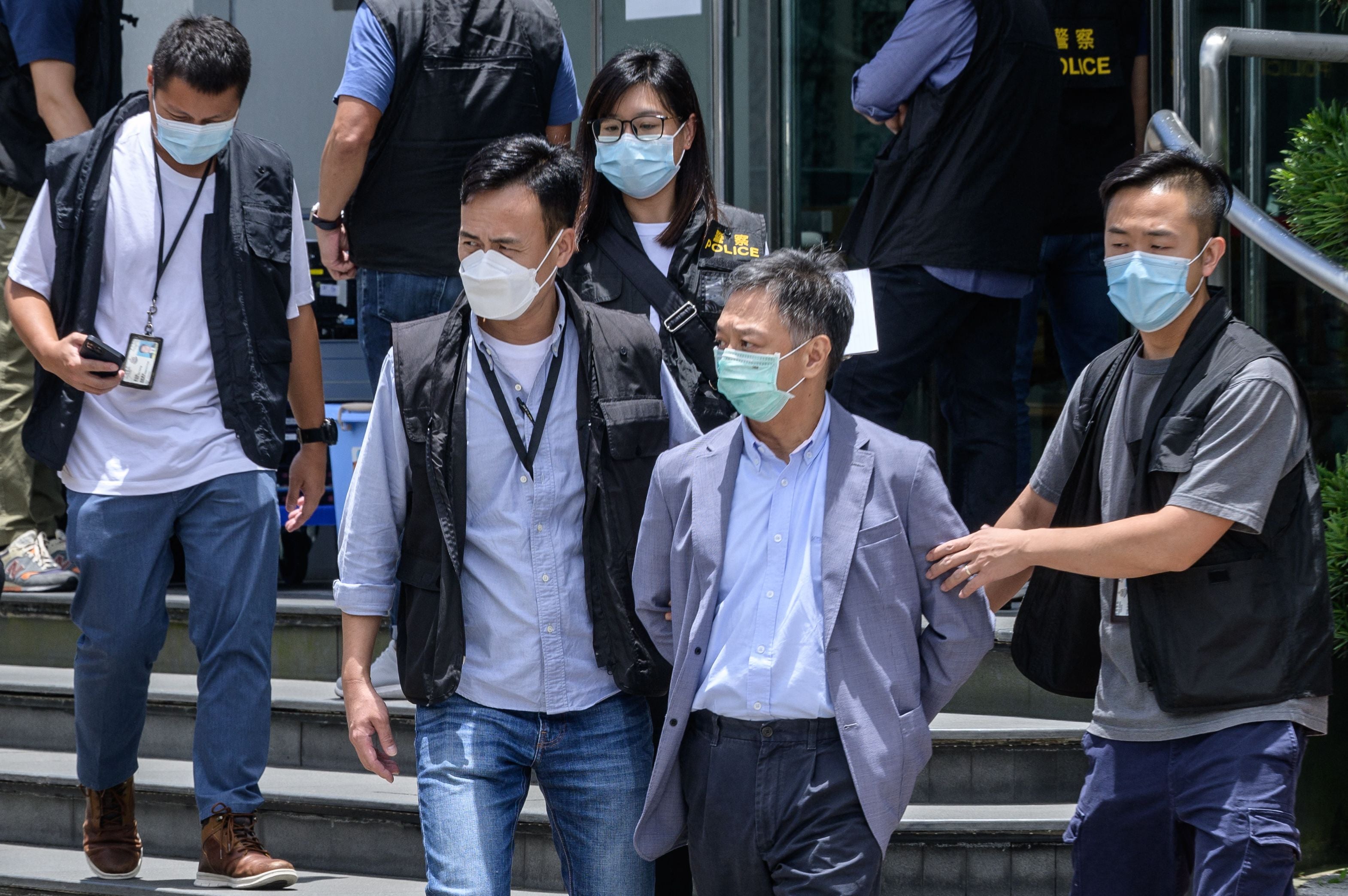 Apple Daily Chief Operations Officer Chow Tat Kuen escorted by police from the Apple Daily offices