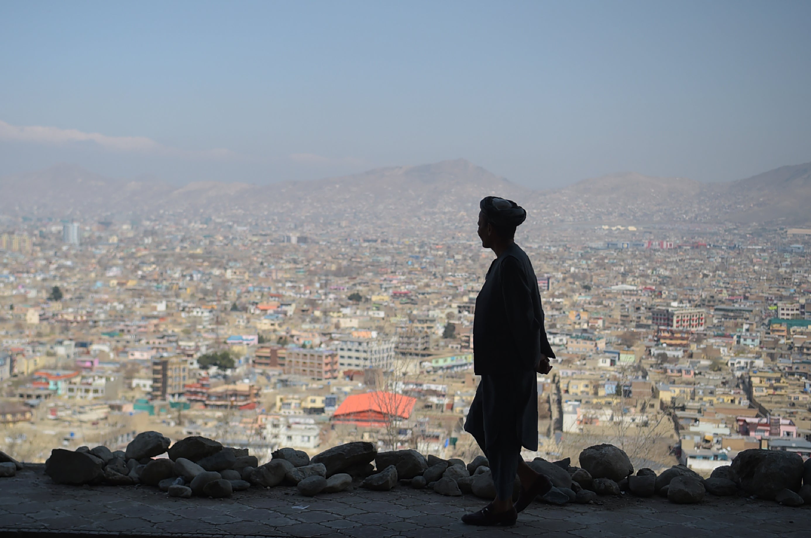 An Afghan man walks during the first day of the Nowruz (Noruz), or Persian New Year, in a hilltop overlooking of Kabul on March 21, 2018.