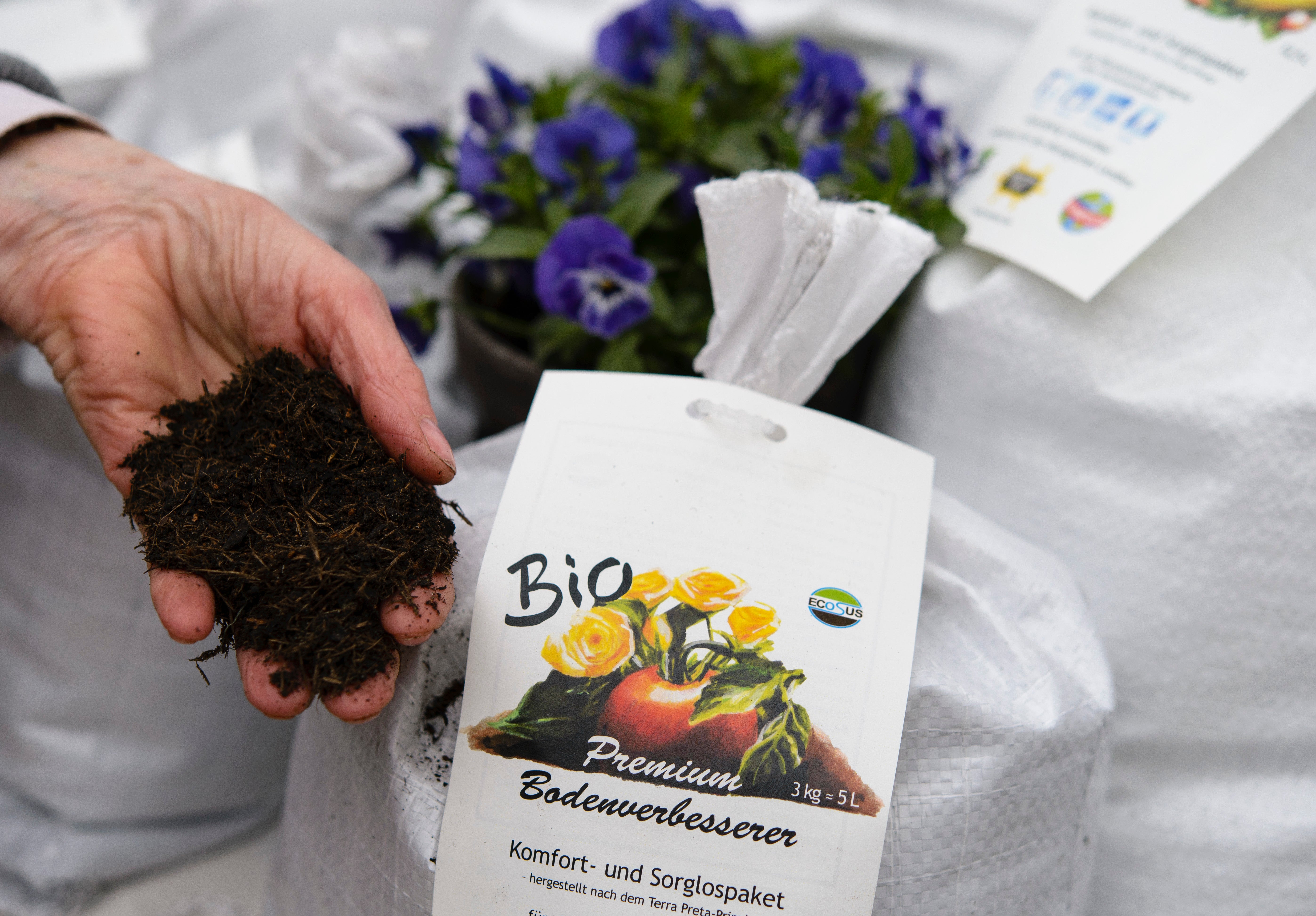 File A sales assistant shows organic flower soil at the biannual gardeners’ market at the Botanical Gardens on April 5, 2014 in Berlin