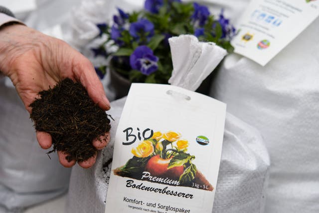 <p>File  A sales assistant shows organic flower soil at the biannual gardeners’ market at the Botanical Gardens on April 5, 2014 in Berlin</p>