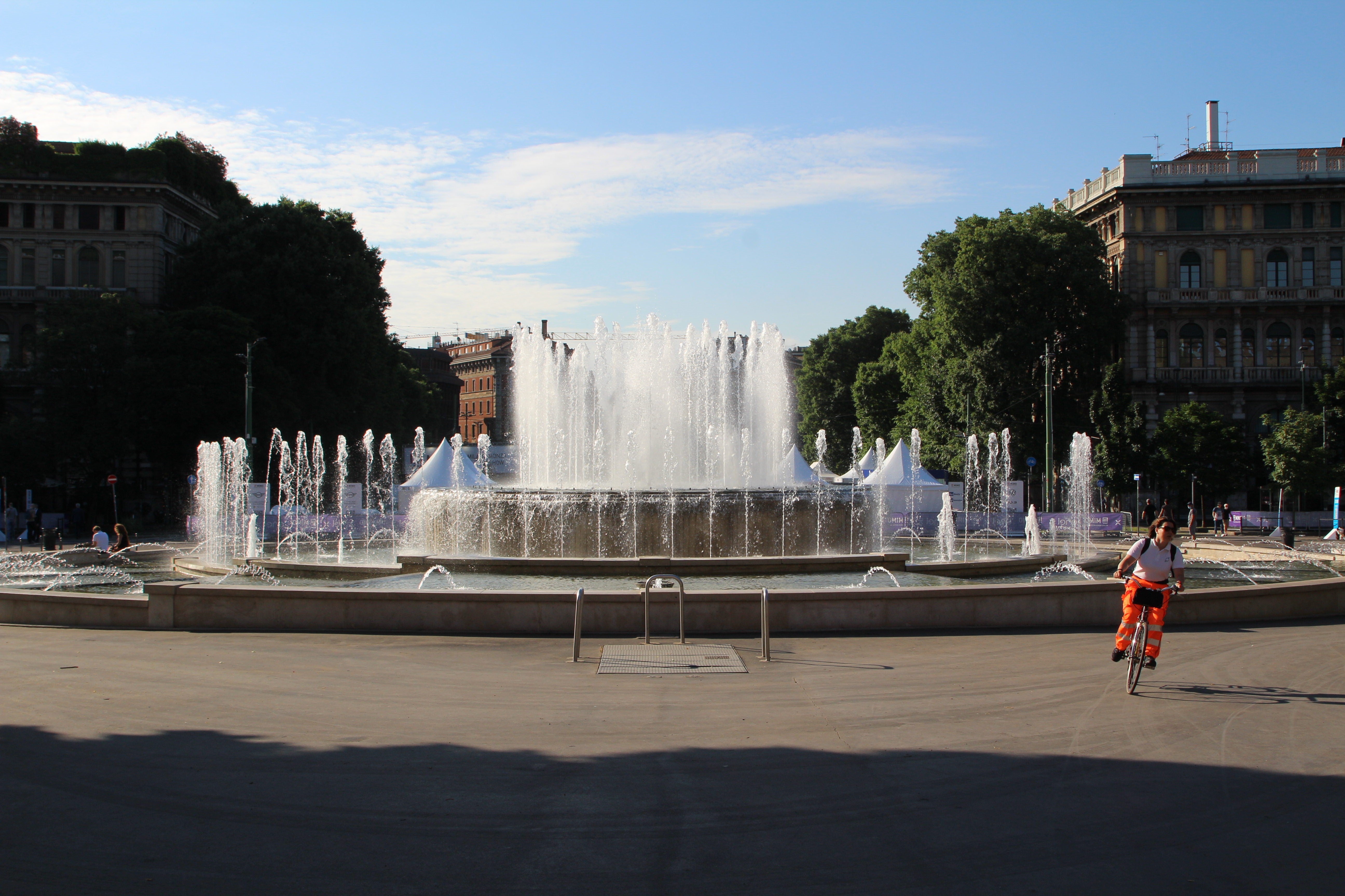 Cyclist rides past a fountain at Parco Sempione