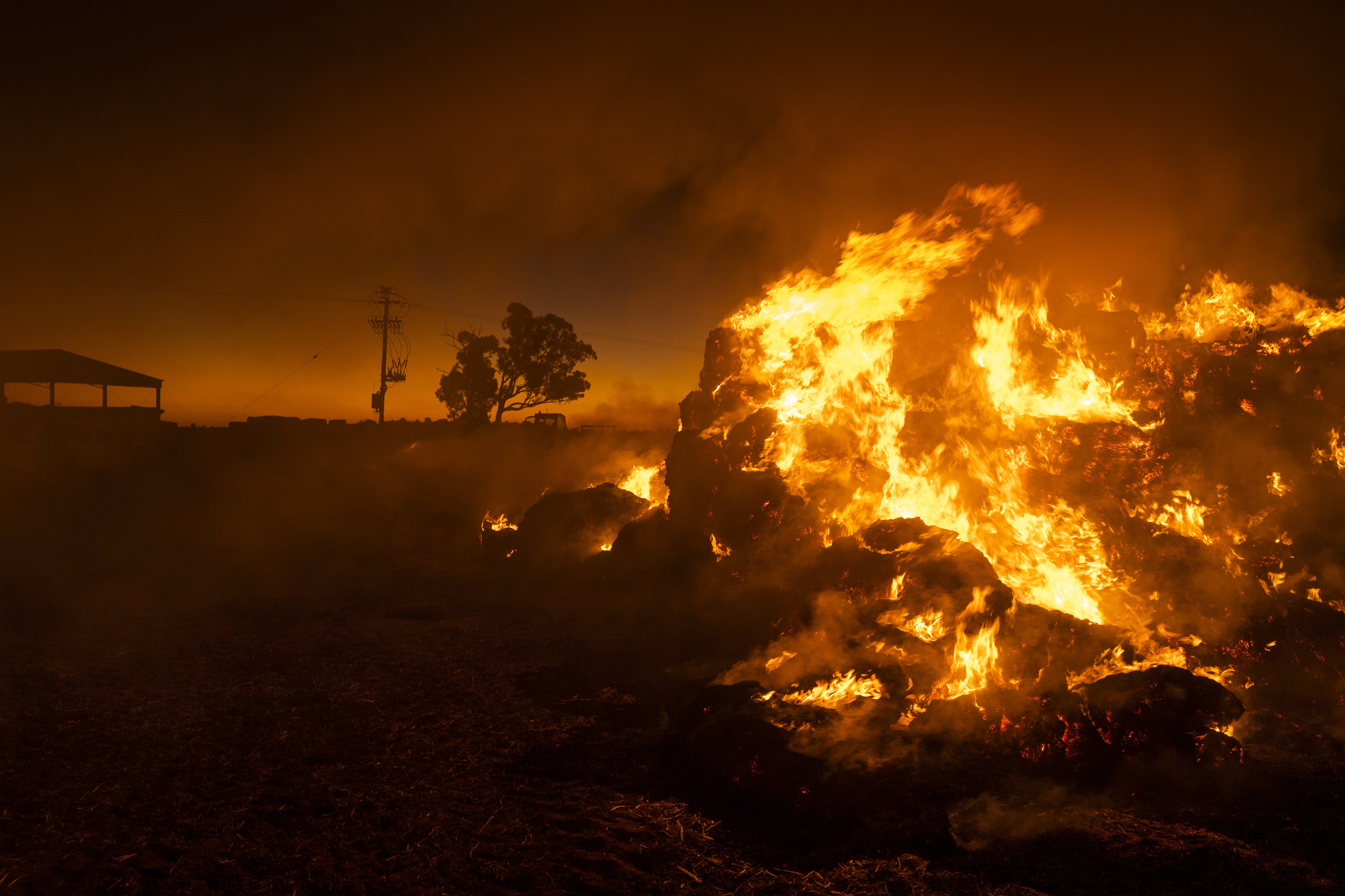 Farmer Greg Younghusband burns approximately 130 bales of hay that have been destroyed by mice near Gilgandra, New South Wales, Australia on 26 May 2021