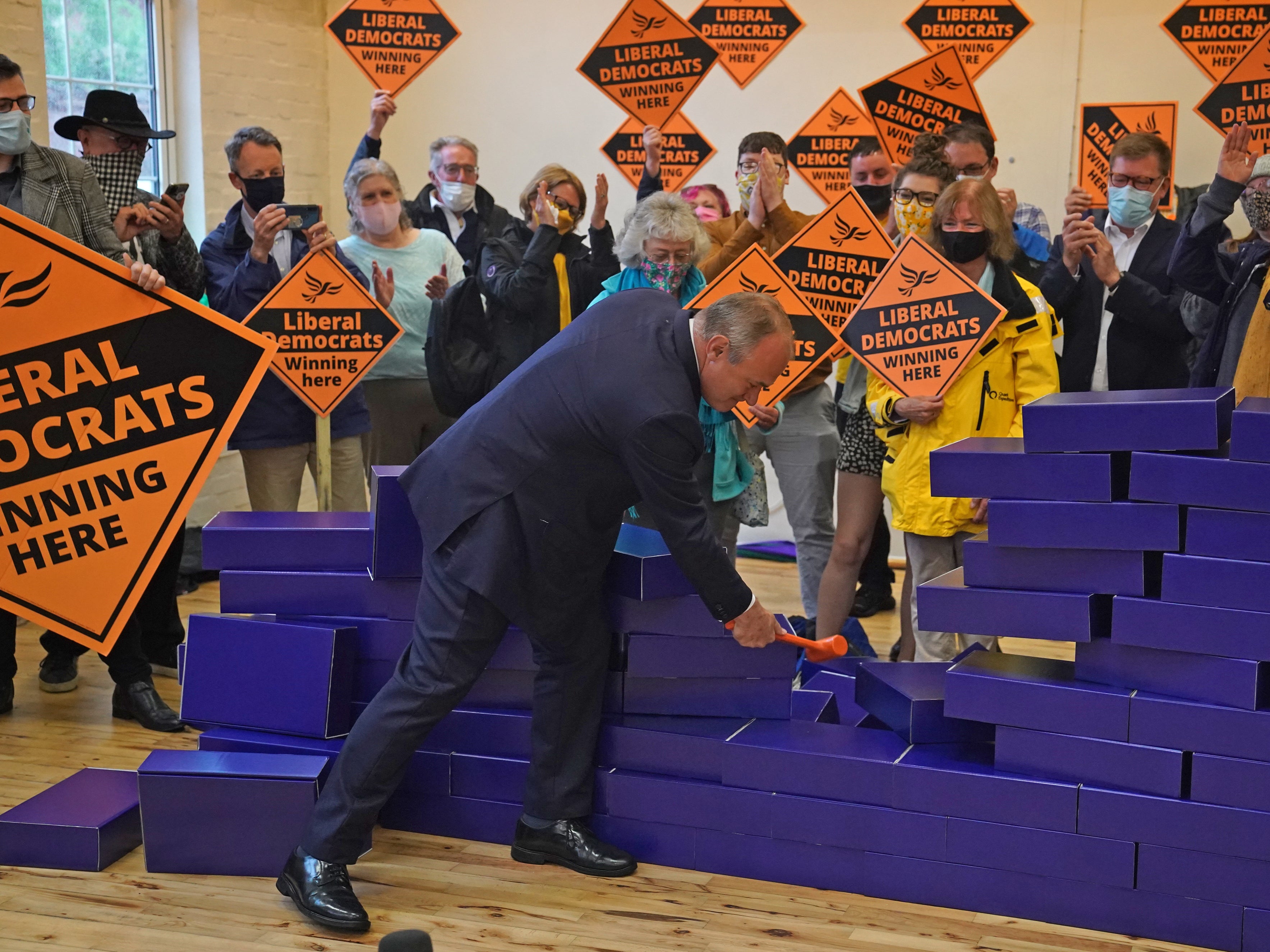 Ed Davey smashes a symbolic blue wall after the by-election win in Chesham and Amersham for the Liberal Democrats