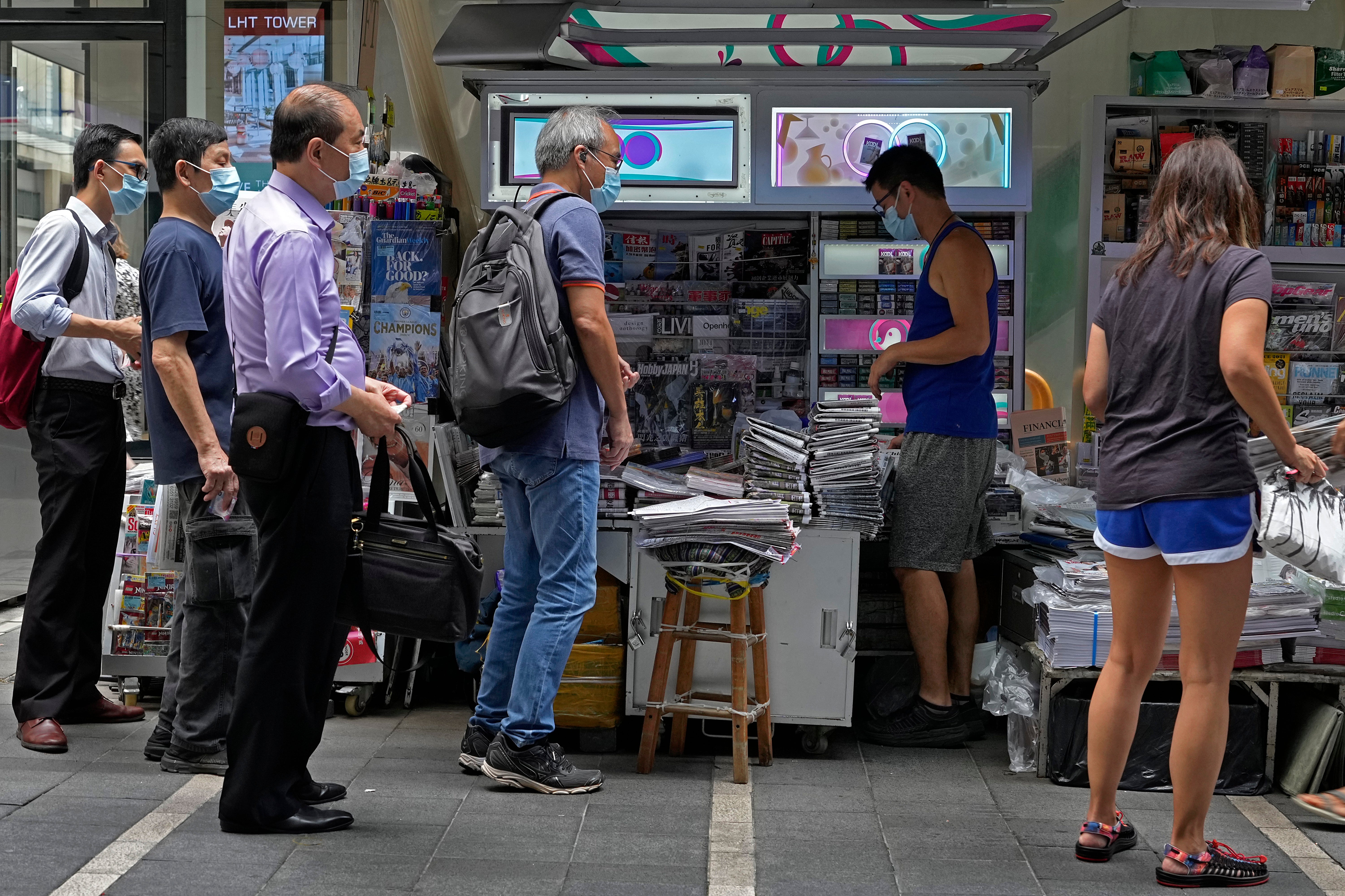 People queue up to buy the Apple Daily newspaper in Hong Kong