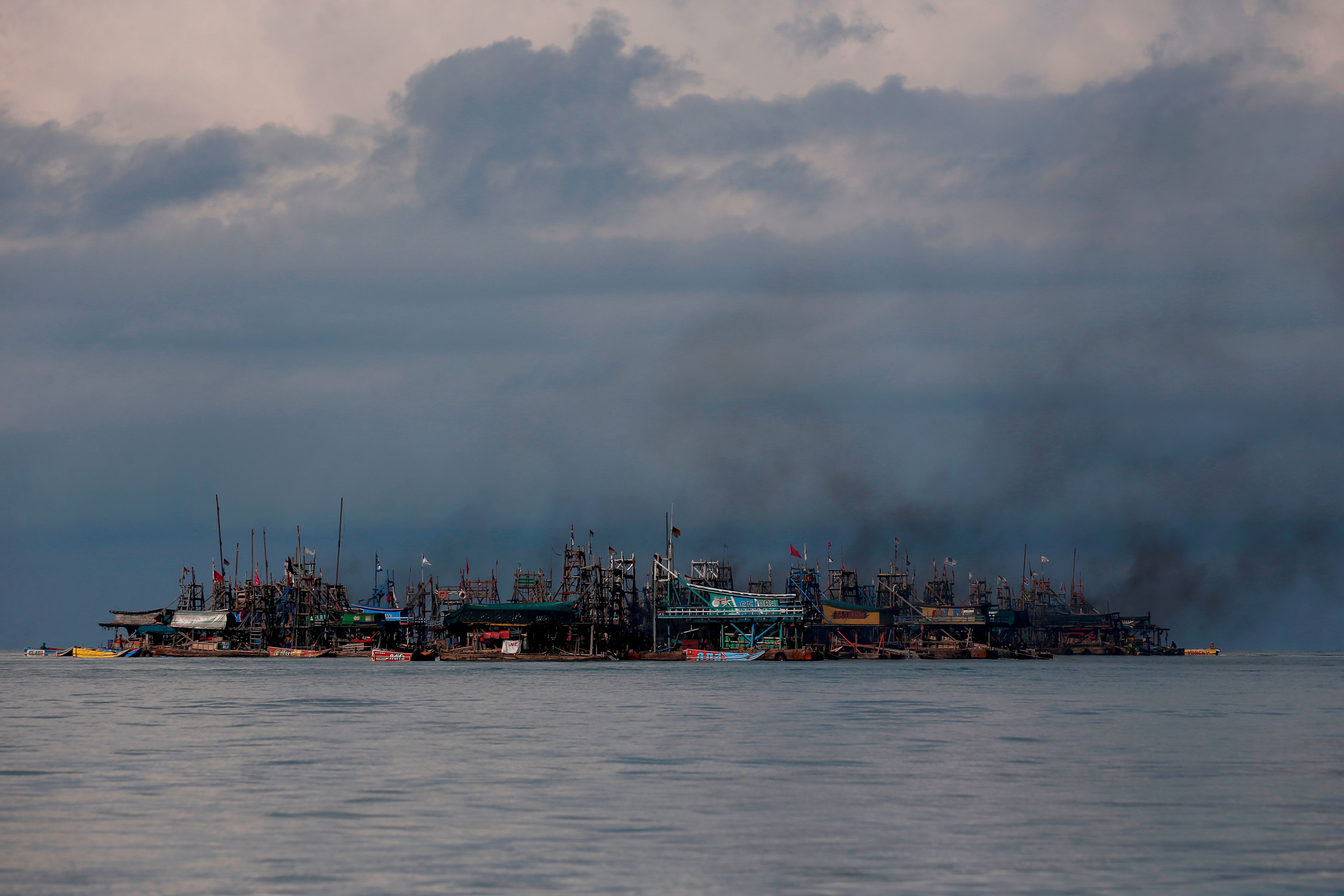 Smoke from diesel generators rises from pontoons off the coast of Toboali