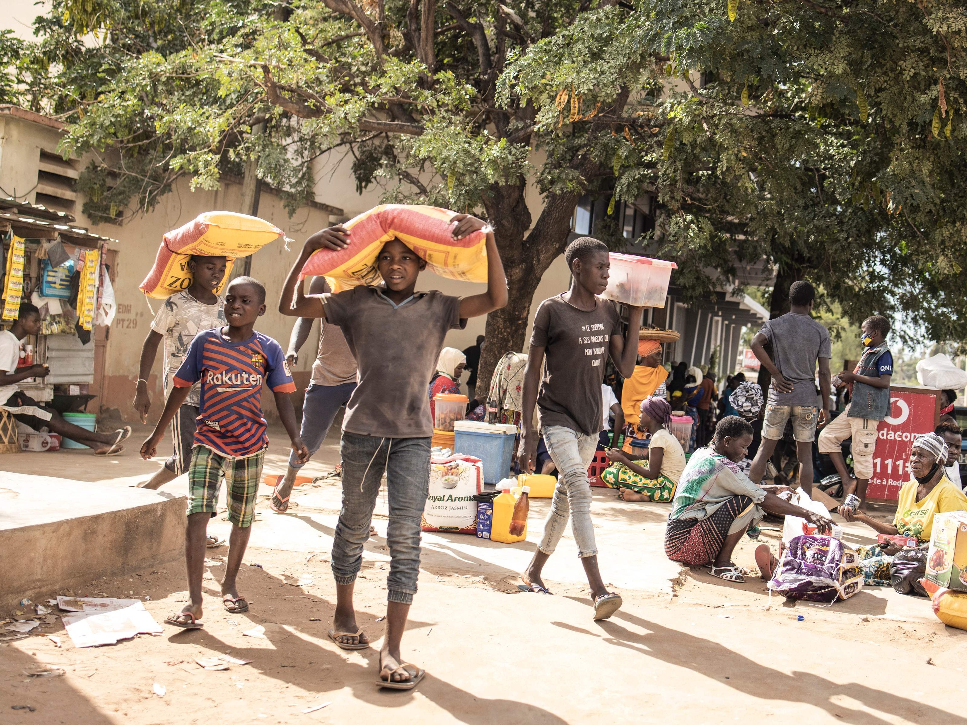 Young boys carry sacks of food after being displaced by violence in northern Mozambique