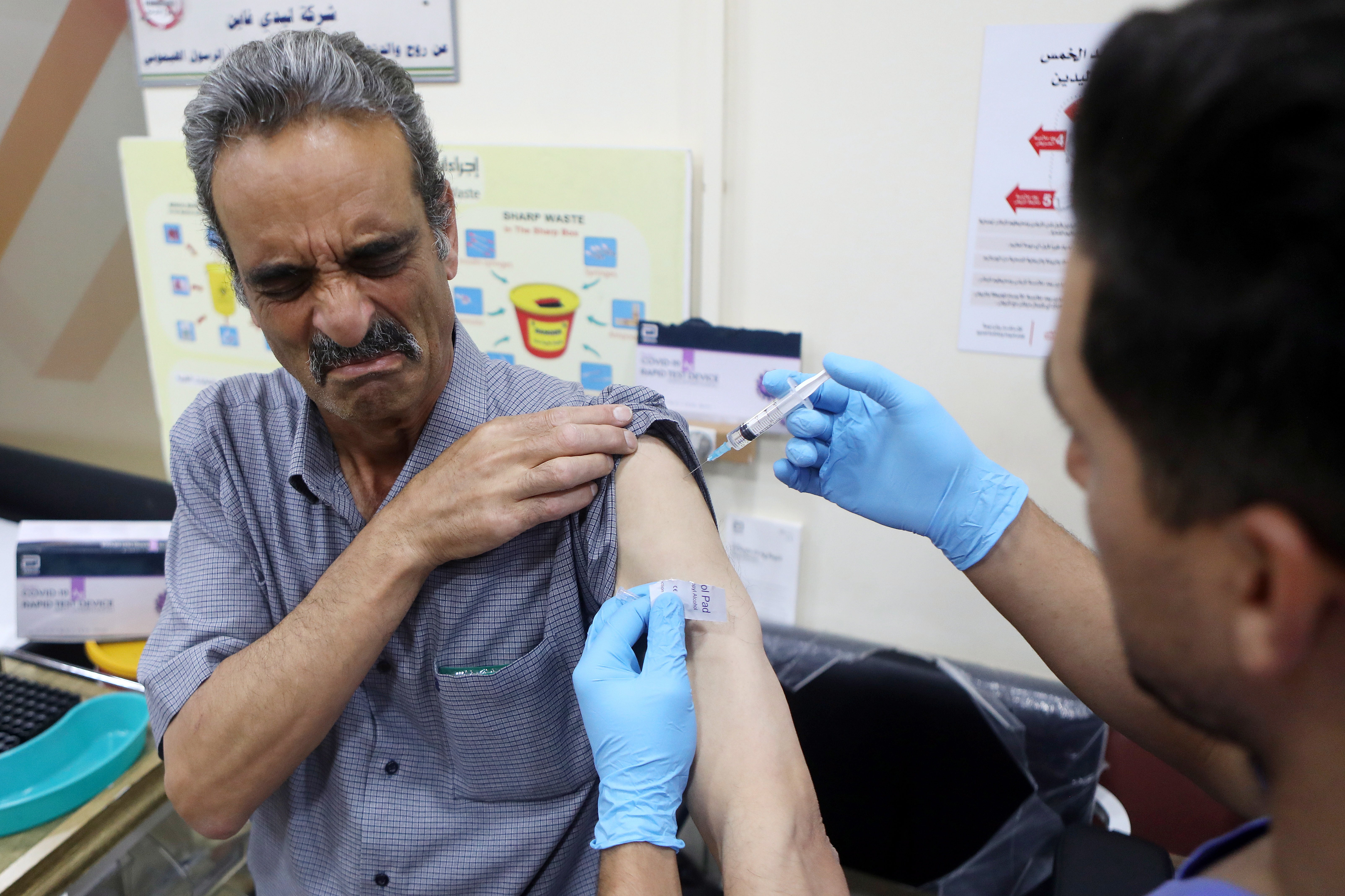 A Palestinian medical worker receives a Covid-19 vaccine at the Palestinian Red Crescent Hospital in the West Bank city of Hebron
