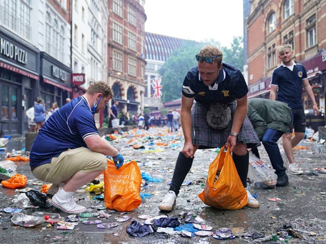 <p>Ventiladores de Escocia limpian la basura en Irving Street, cerca de Leicester Square, Londres.</p>