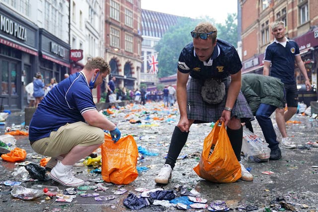 <p>Scotland fans clean up litter in Irving Street  near Leicester Square, London.</p>