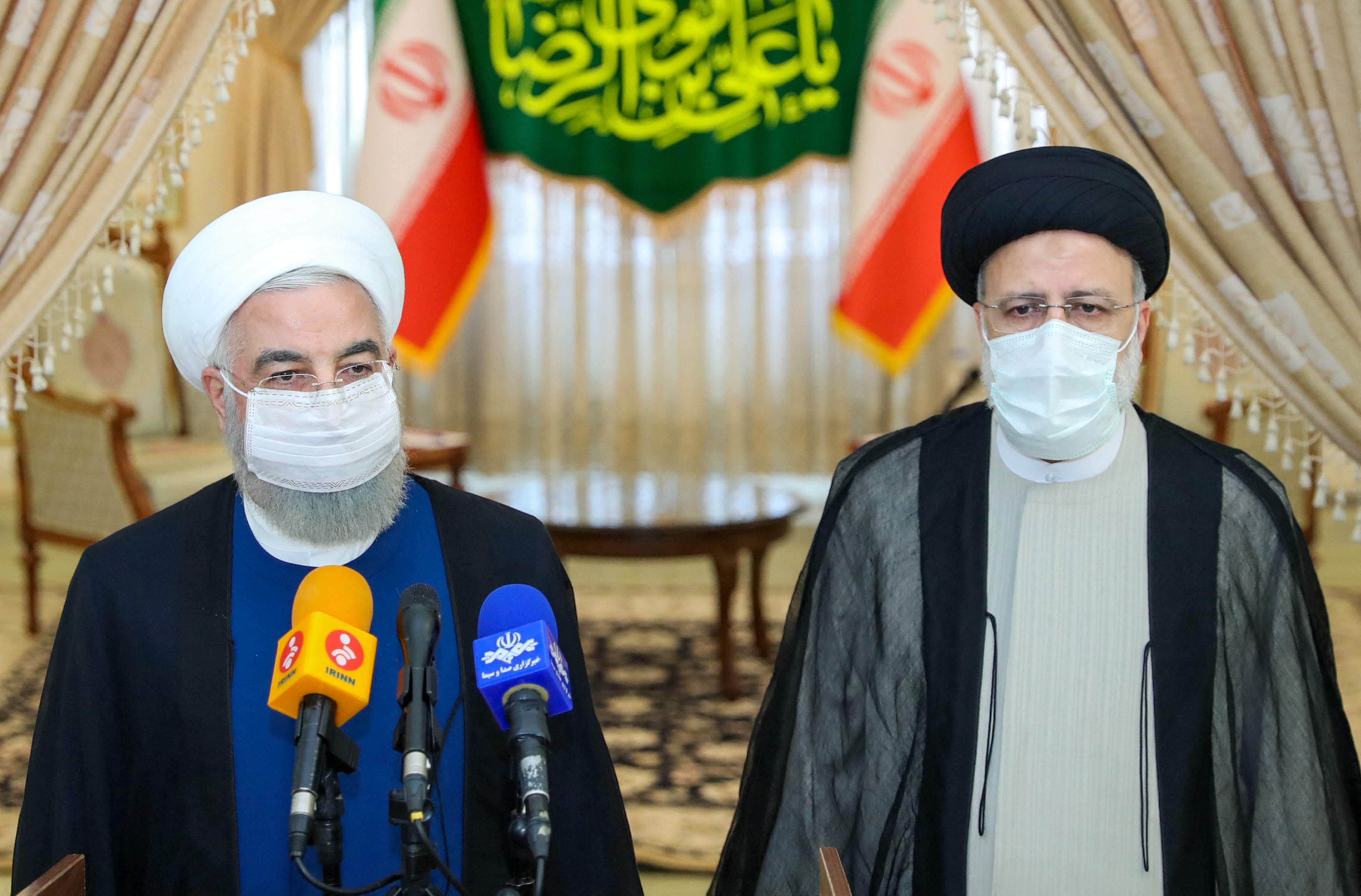 Outgoing president Hassan Rouhani (L) takes part in a press conference with president-elect Ebrahim Raisi