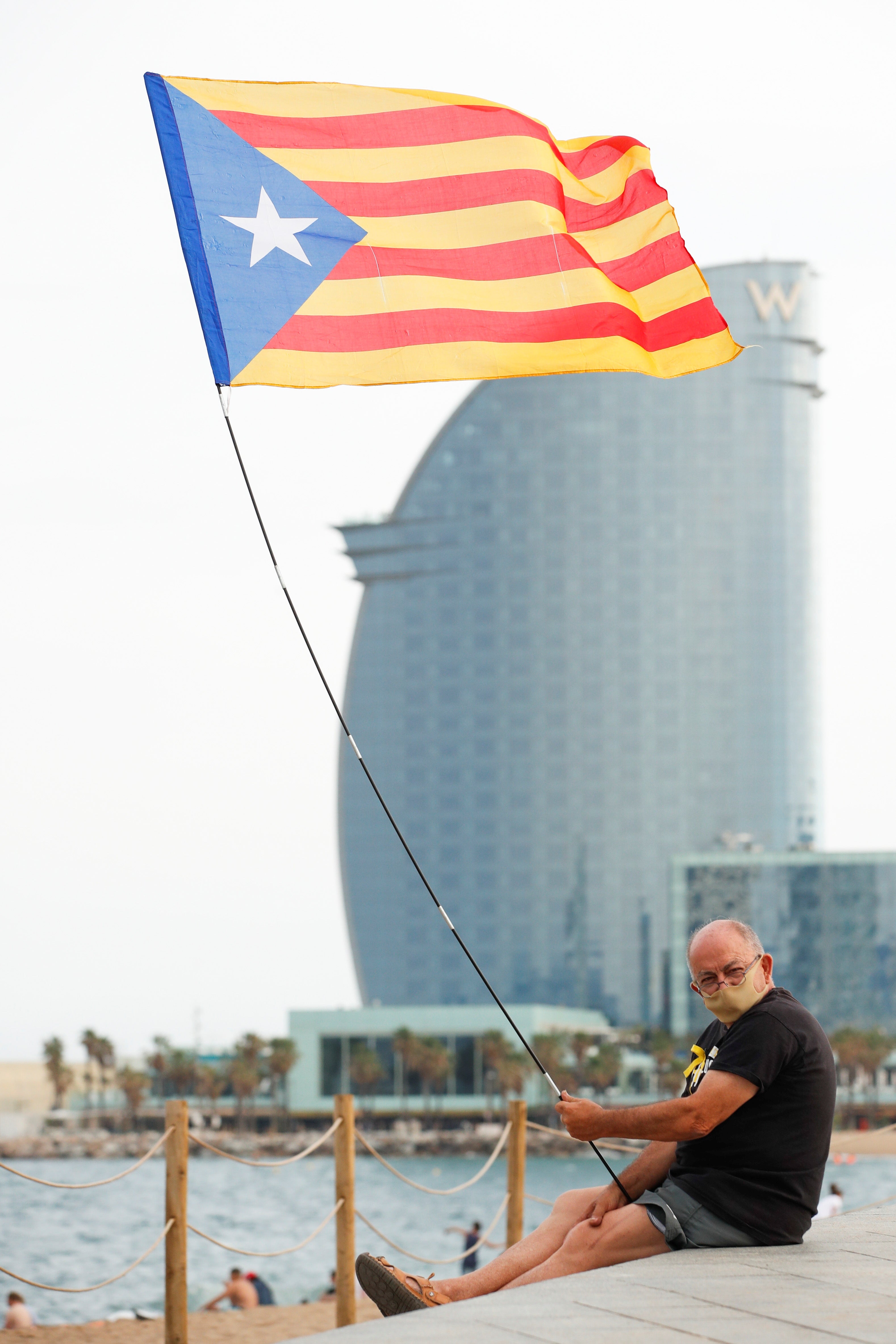 A man holds an Estelada flag (the Catalan pro-independence flag) in Barcelona