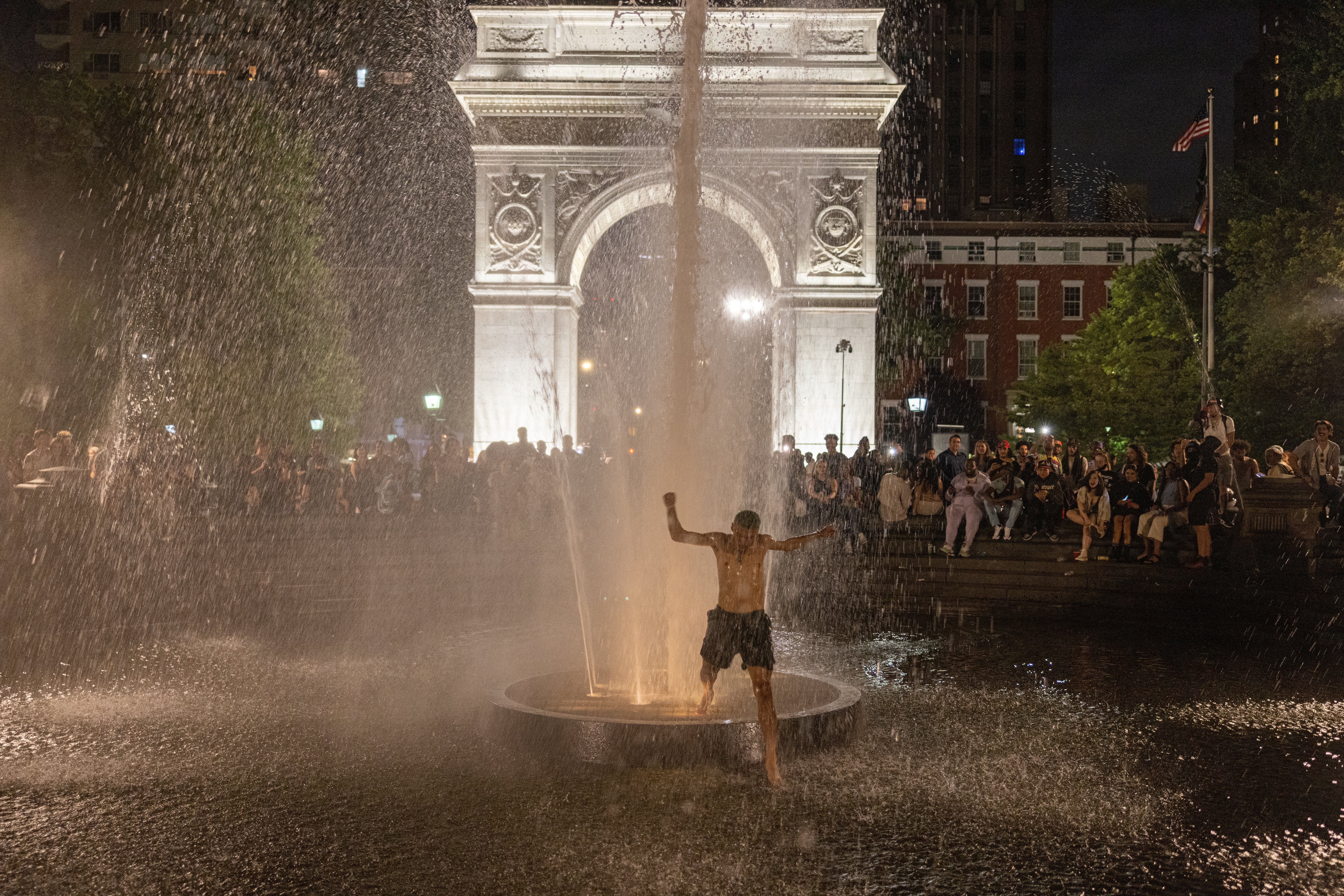 Partygoers in Washington Square Park run through the fountain drawing cheers from onlookers on June 18, 2021 in New York City