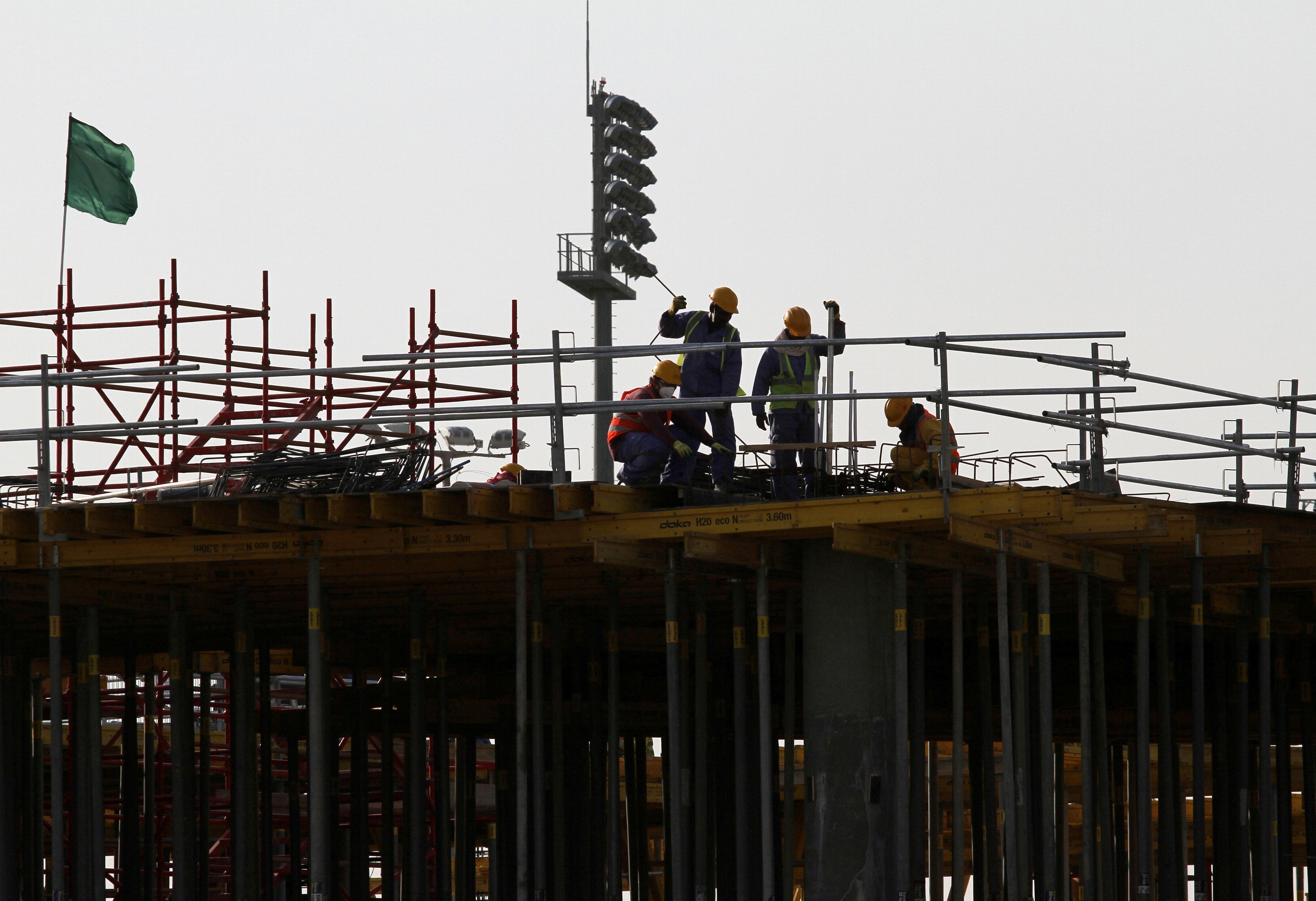 <p>Migrant labourers work at a construction site at the Aspire Zone in Doha</p>