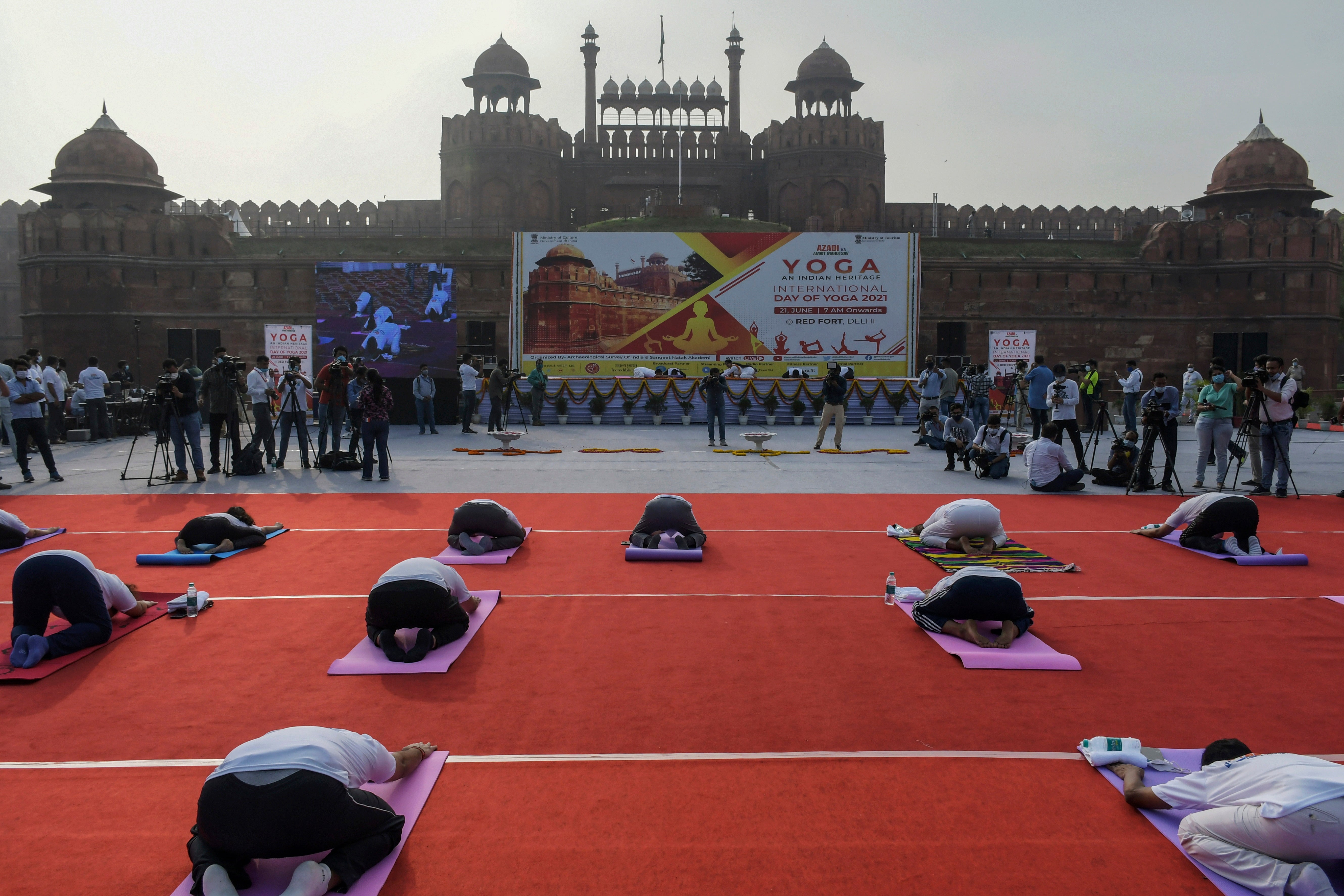 People perform yoga in front of the Red Fort monument in New Delhi.
