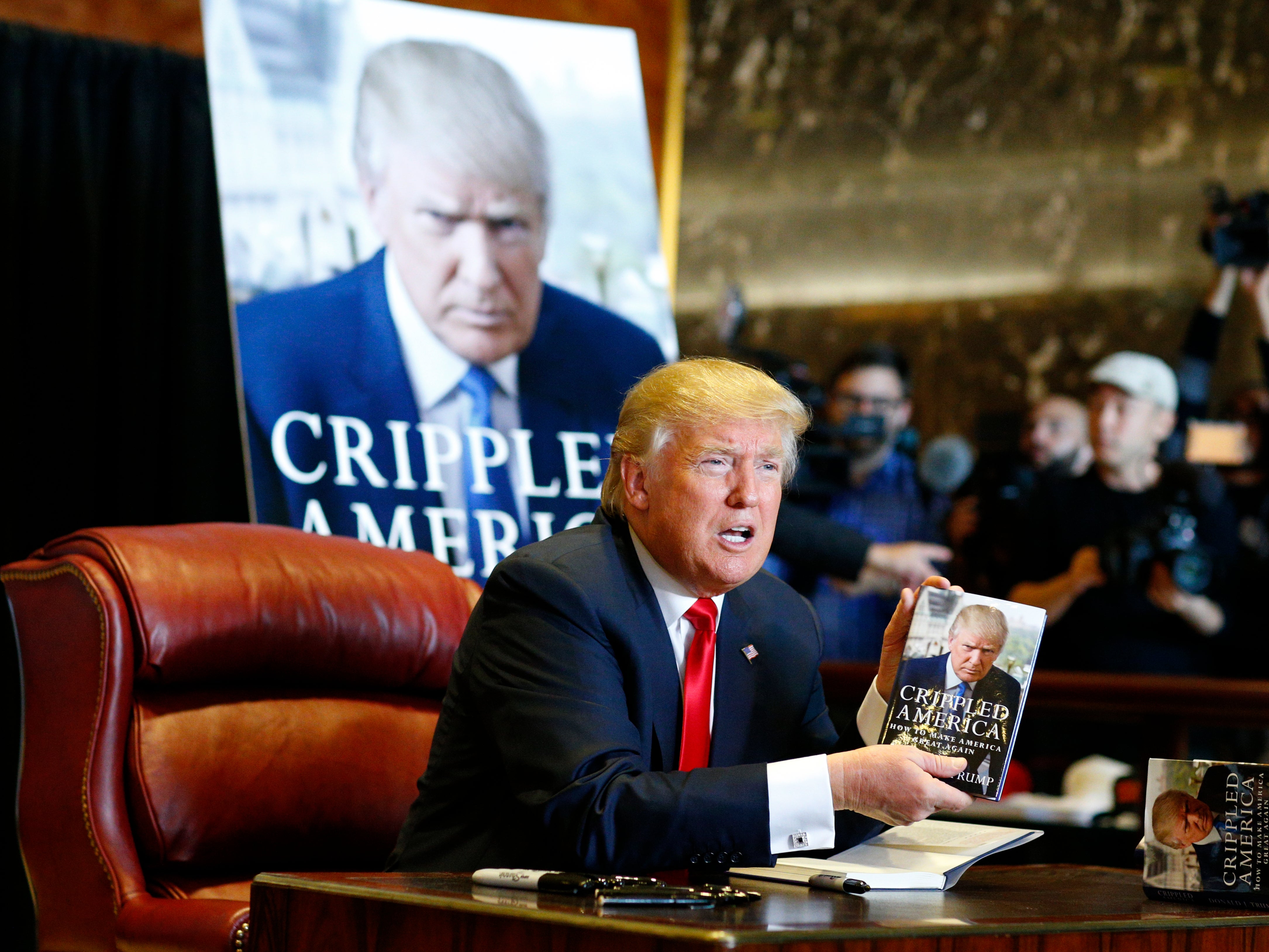 Donald Trump signs copies of his 2015 book, Crippled America