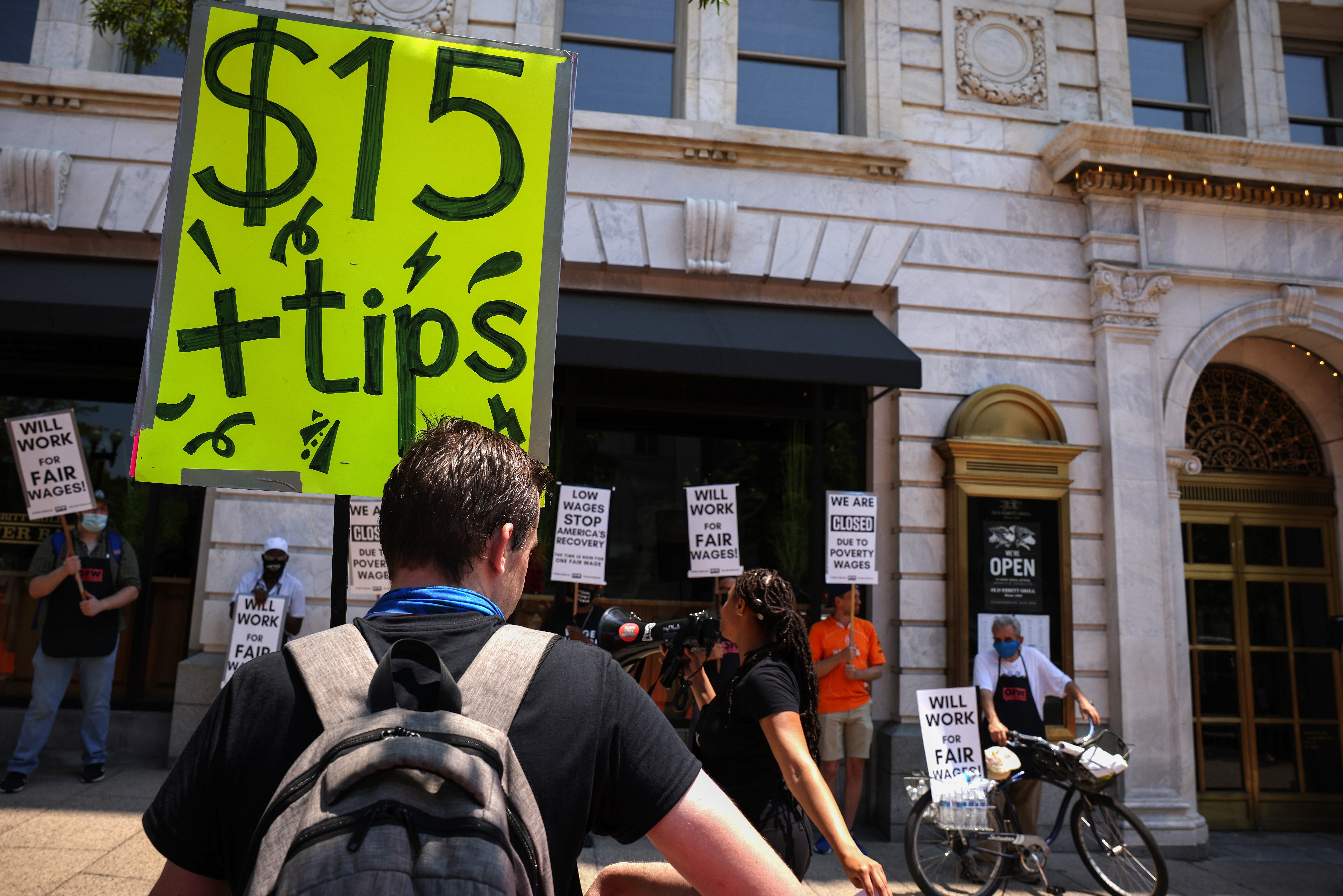 An activist holds a sign up outside Old Ebbitt Grill restaurant during a “Wage Strike” demonstration on May 26th, 2021 in Washington, DC. Delaware lawmakers have voted to give final approval to raising the state’s minimum wage to $15 an hour.