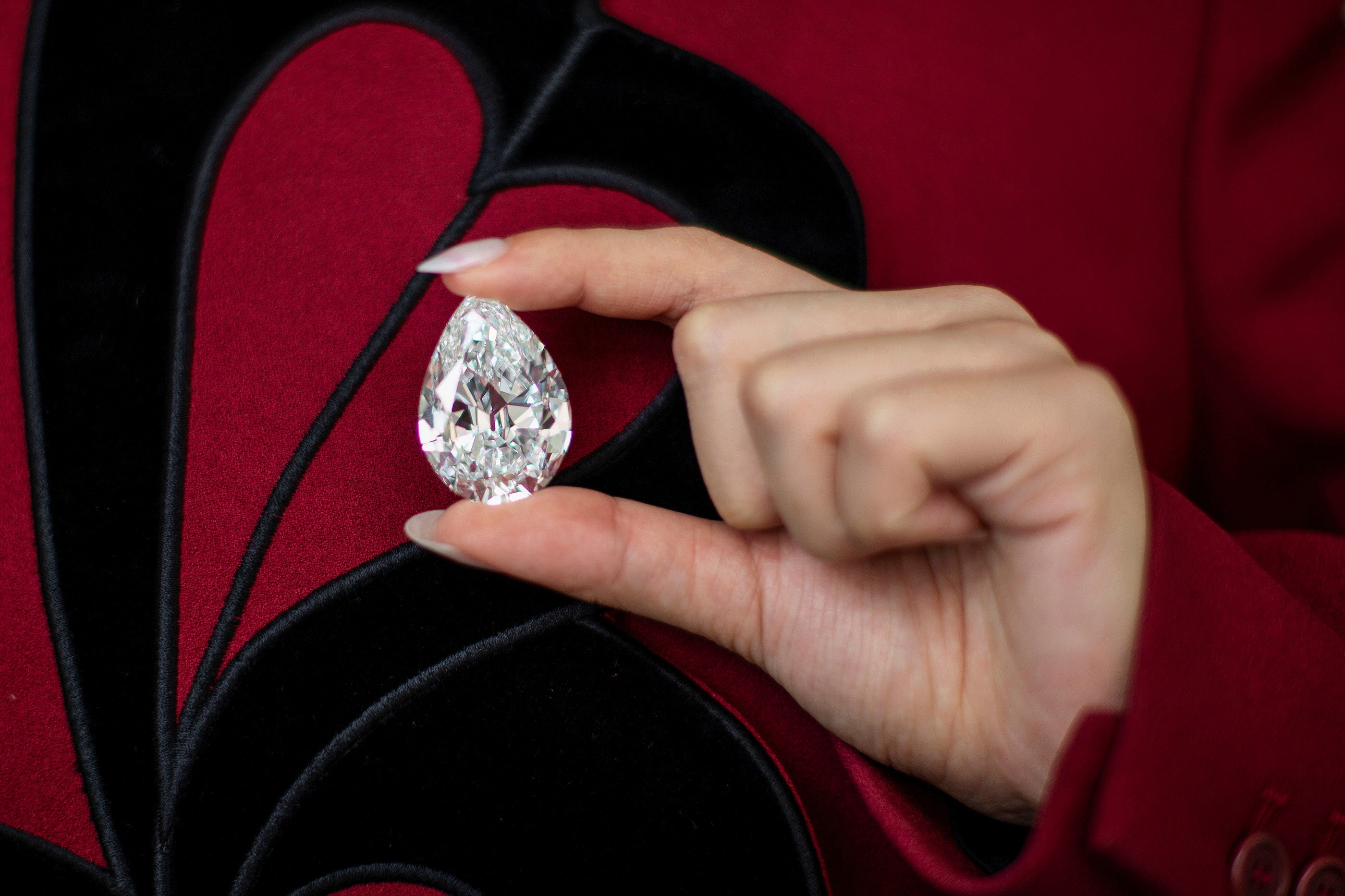 An employee of Sotheby's poses with a rare pear-Shaped D Colour Flawless 100+ carat diamond at Sotheby's in New York City, New York, US, 21 June, 2021