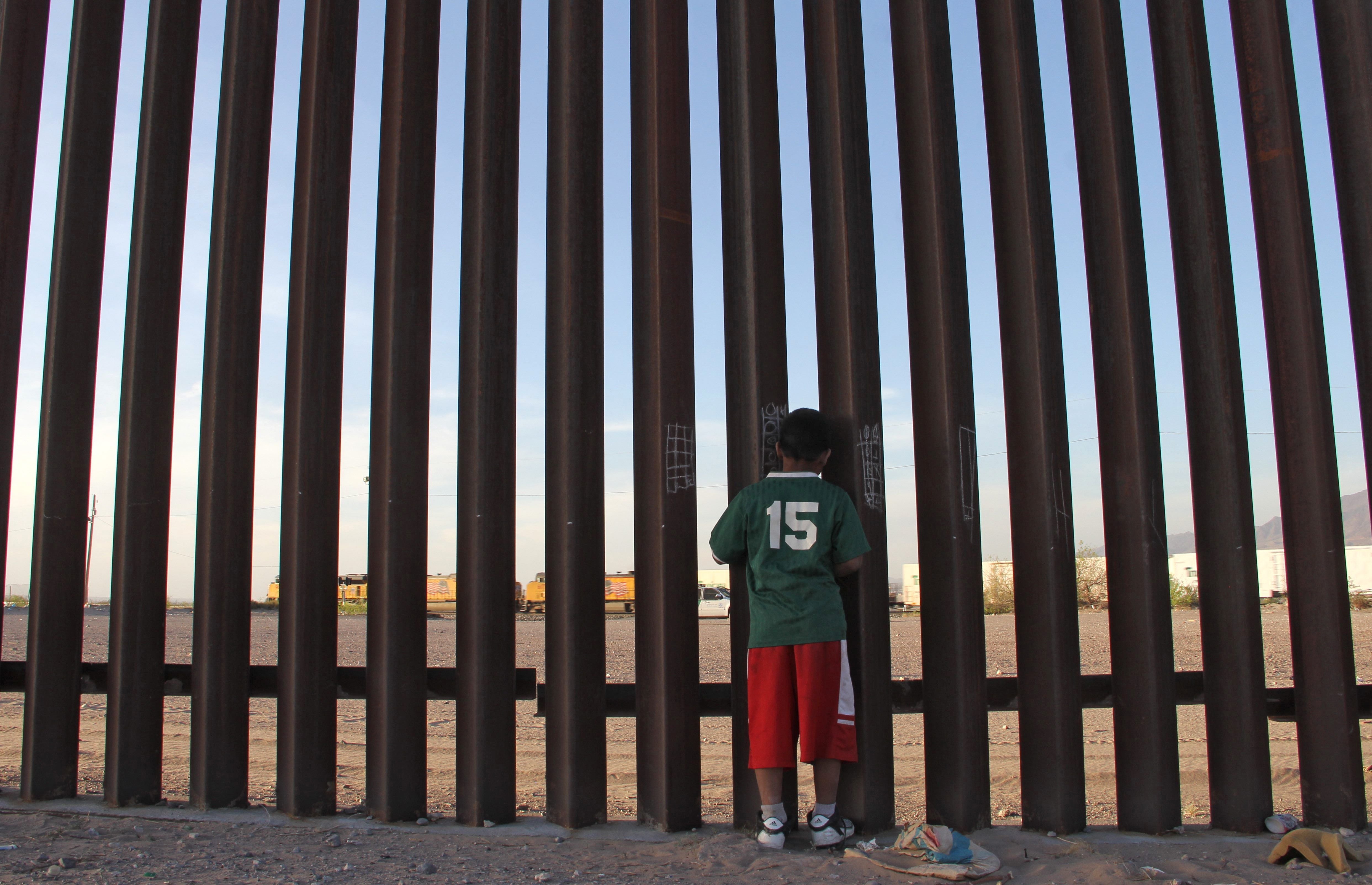 A Mexican child looks at a vehicle of the US border patrol through the US-Mexico fence in Ciudad Juarez, Chihuahua state, Mexico. Human rights organisations have urged the US government to stop deporting Mexican children in rapid removals.