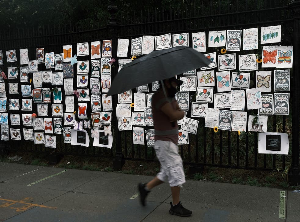 <p>A man walks past a memorial in New York City to those who have died during the Covid-19 pandemic. </p>