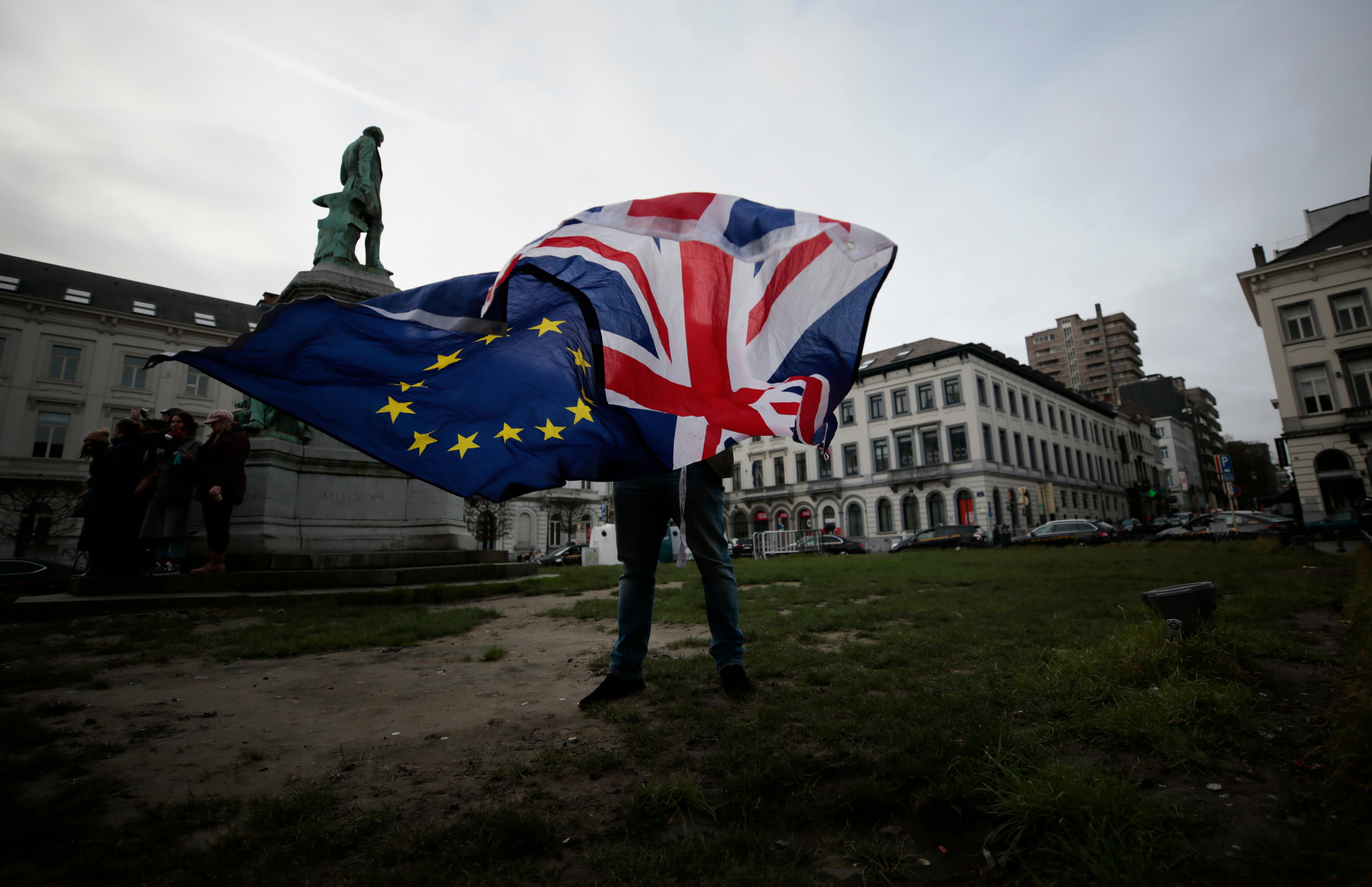 A man unfurls a union and EU flag outside the European parliament in Brussels