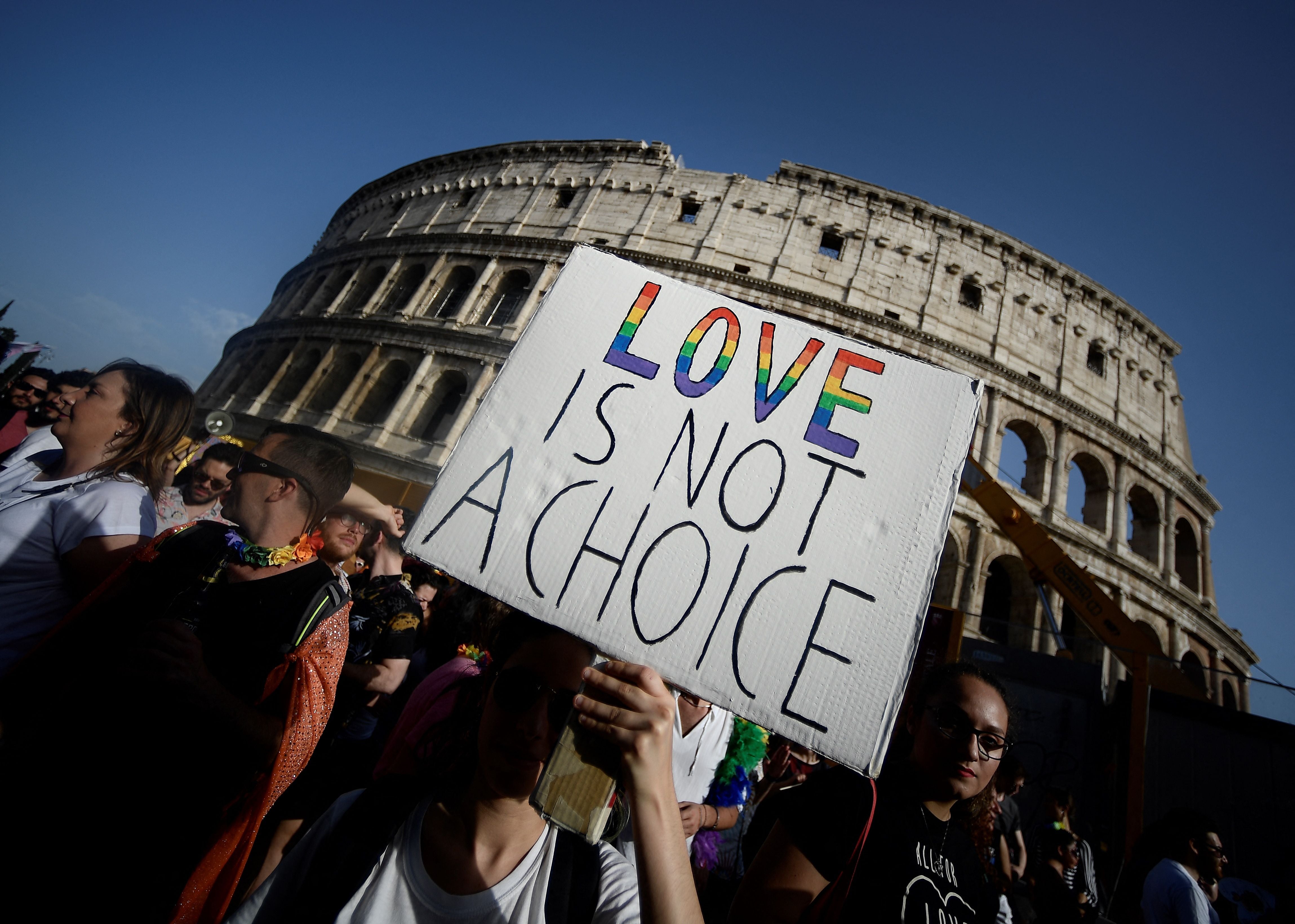 Participants walk past the Colosseum monument in Rome during the annual Gay Pride parade
