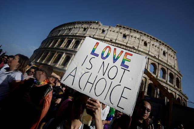 <p>Participants walk past the Colosseum monument in Rome during the annual Gay Pride parade</p>