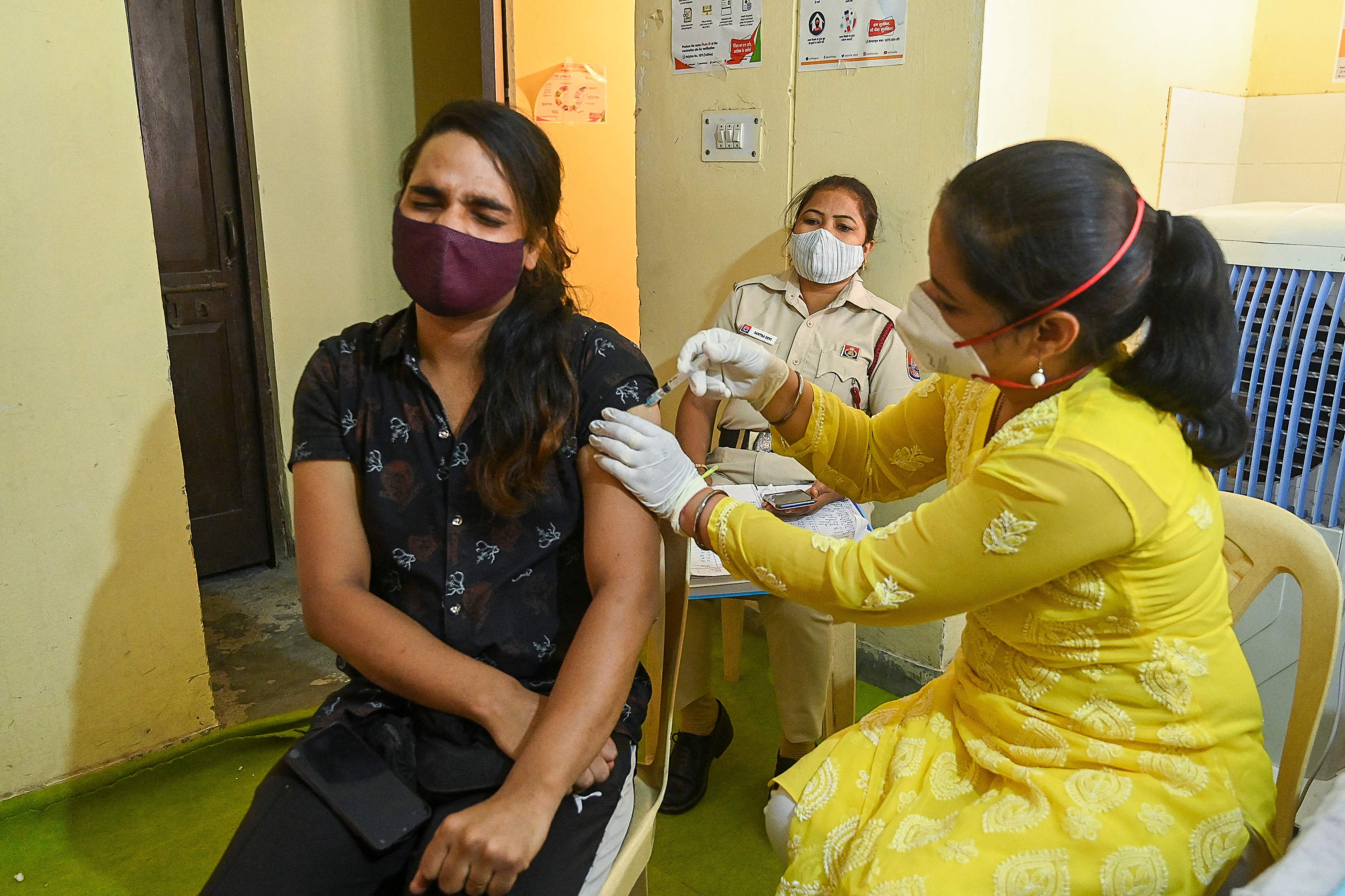 A health worker inoculates a transgender person with a dose of the Covishield vaccine against the Covid-19 coronavirus at a vaccination centre in New Delhi on 23 June, 2021