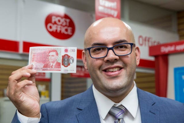 Postmaster Ahmed Butt holding the new £50 banknote
