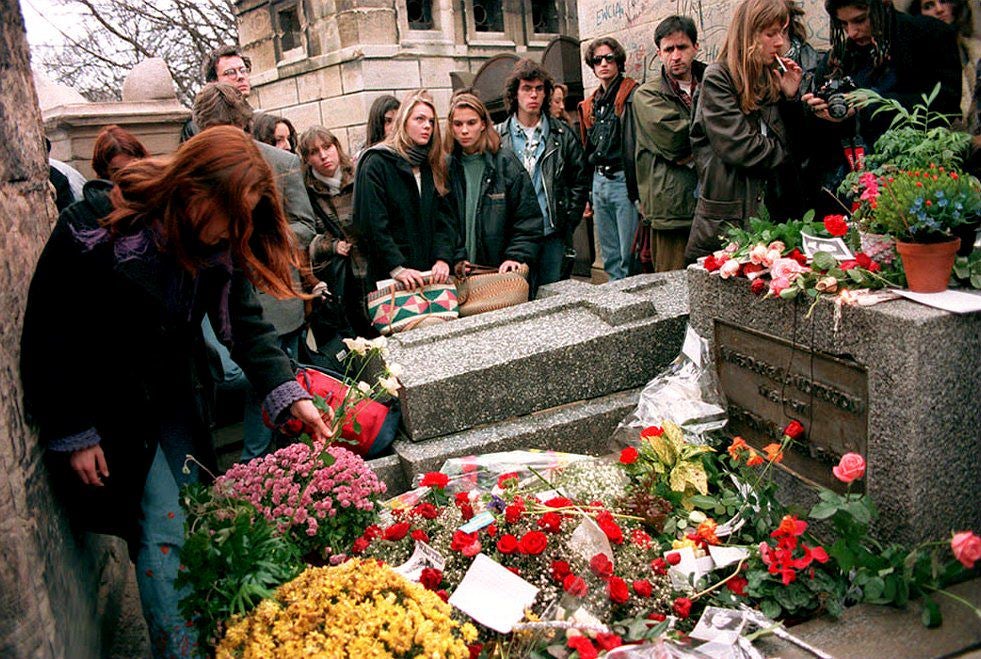 Fans lay flowers on the tomb of Jim Morrison at the Pere Lachaise cemetery, the fourth most popular tourist attraction in Paris