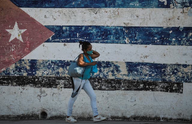 <p>A woman walks near a wall depicting the Cuban flag in Havana as the UN meets in New York</p>