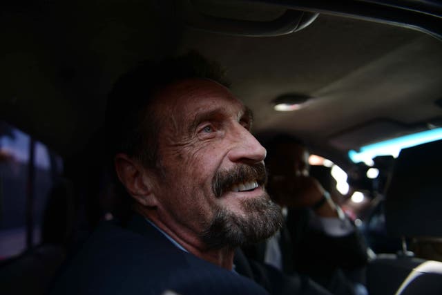 <p>US anti-virus software pioneer John McAfee smiles as he arrives at the Aurora international airport in Guatemala City on December 12, 2012. Mr McAfee was found dead in his prison cell in Spain on Wednesday, 23 June, 2021.</p>
