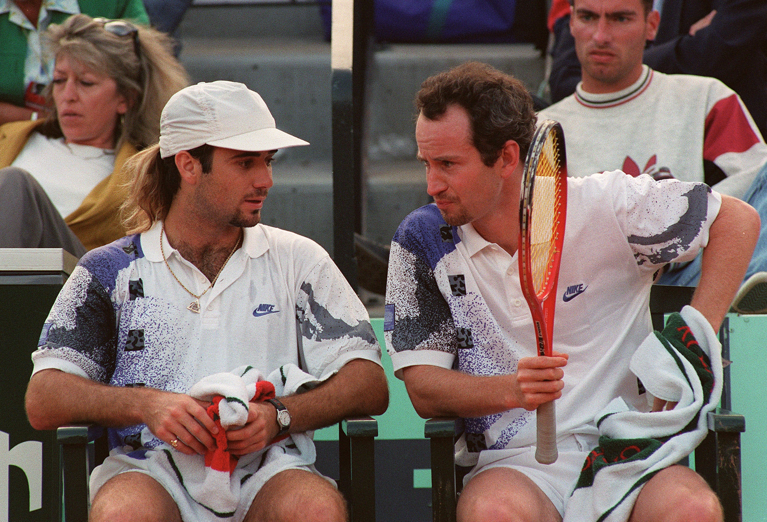 Andre Agassi and McEnroe discuss tactics in their doubles game during the 1992 French Open