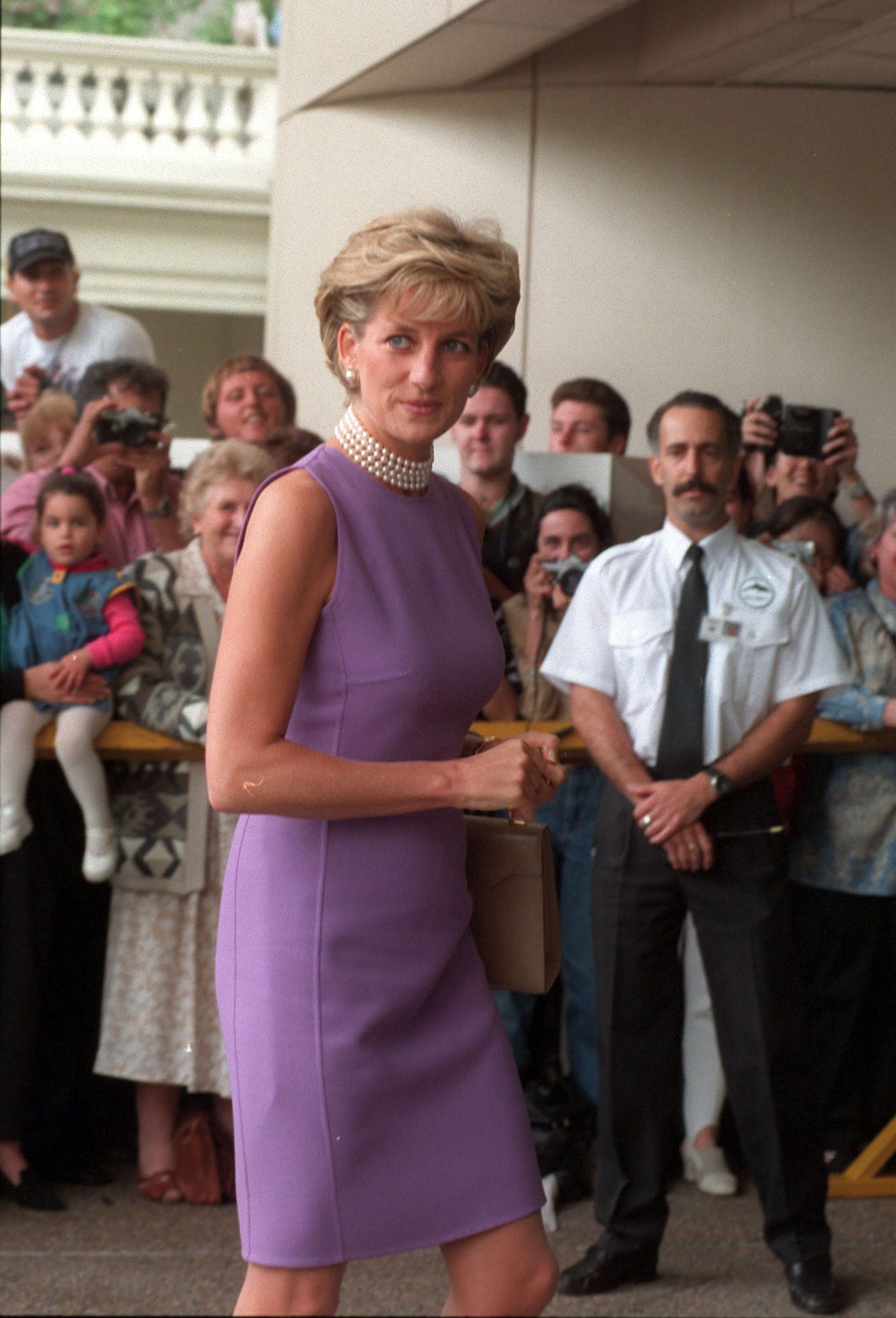 In one of her more reserved looks in 1996, Diana chose a lilac shift dress with a pearl choker, neither of which would look out of place today, either in the workplace or during an evening dinner out.