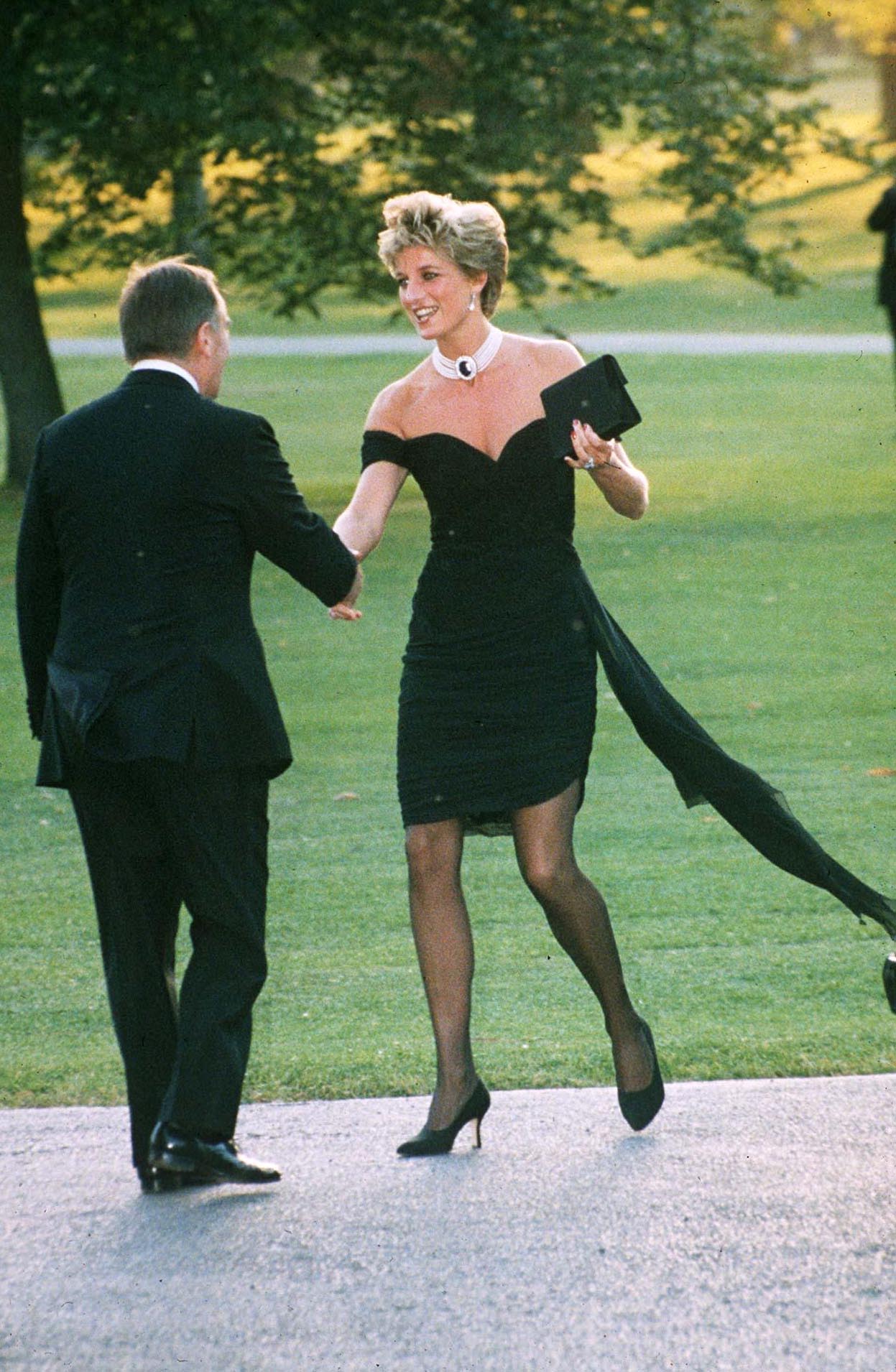 This is probably Diana’s most famous look of all time. Known as “the Revenge dress”, this black silk Christina Stambolian gown was worn by Diana to the Serpentine Gallery summer party in 1994 on the same night Prince Charles admitted to having an affair with Camilla Parker-Bowles. Diana paired the form-fitting, off-shoulder gown, with black sheer tights and stilettos.