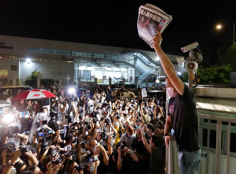 <p>An Apple Daily journalist holds freshly-printed copies of the newspaper’s last edition to be distributed to supporters gathered outside their office in Hong Kong early on 24 June </p>