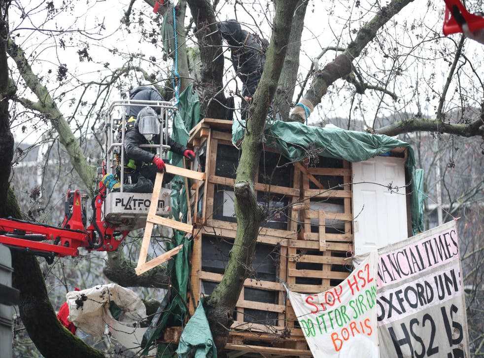 Workers in a cherry picker dismantle a tree house at the HS2 Rebellion encampment in Euston (Yui Mok/PA)