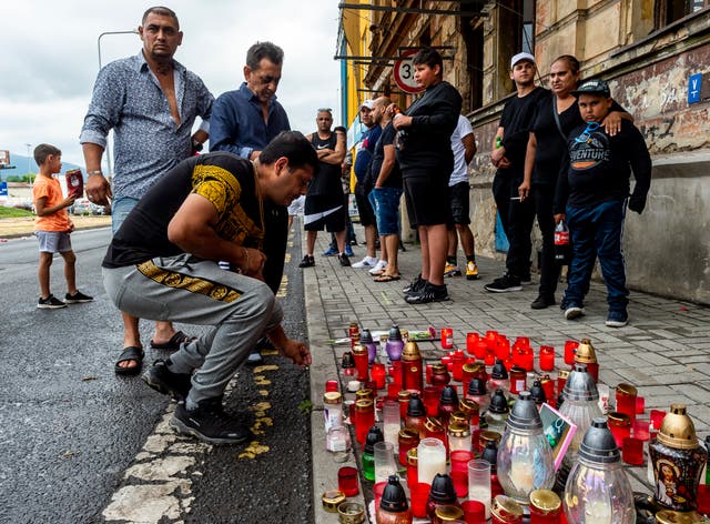 <p>A man lights a candle on Tuesday  in Teplice, Czech Republic, in the place where a Roma man died in an ambulance after a police action on Saturday</p>