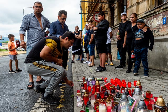 <p>A man lights a candle on Tuesday  in Teplice, Czech Republic, in the place where a Roma man died in an ambulance after a police action on Saturday</p>