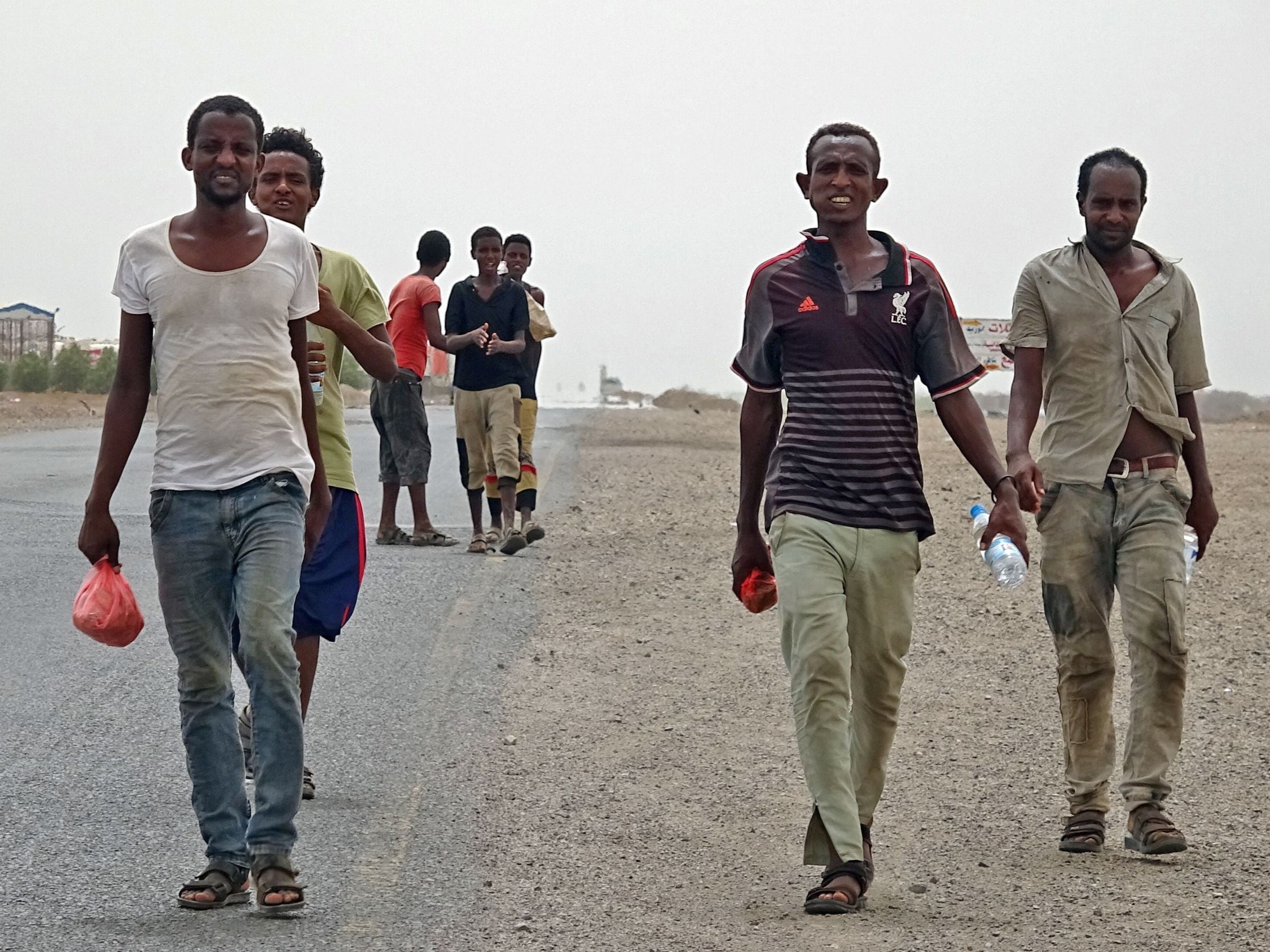 African asylum seekers walk in the coastal area of Ras al-Ara in Yemen’s government-held southern province of Lahij