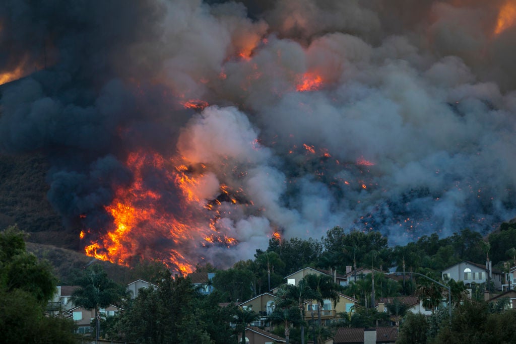 Flames rise near homes during the Blue Ridge Fire on October 27, 2020 in Chino Hills, California